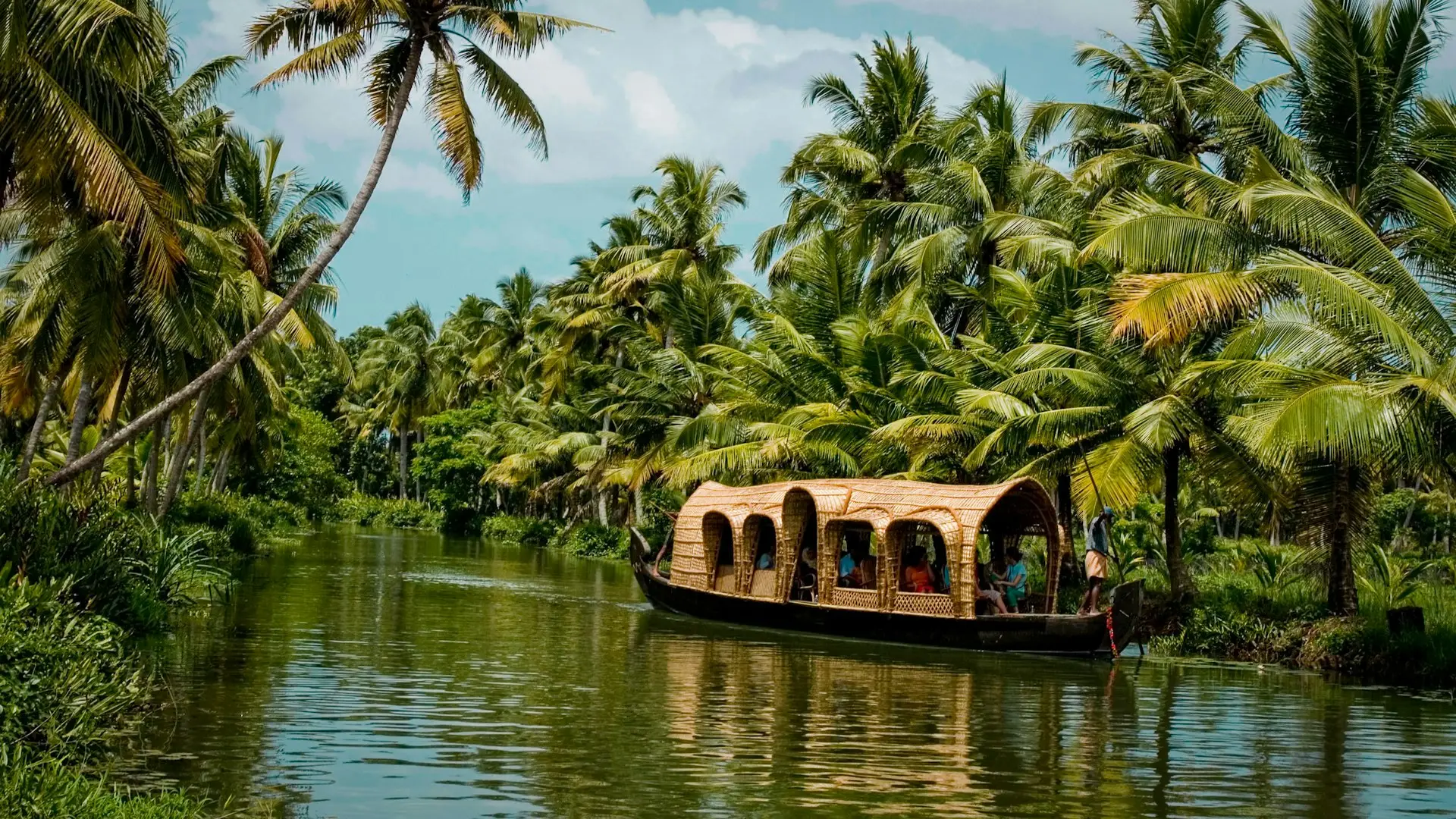 A houseboat on the Kerala backwaters between coconut palms