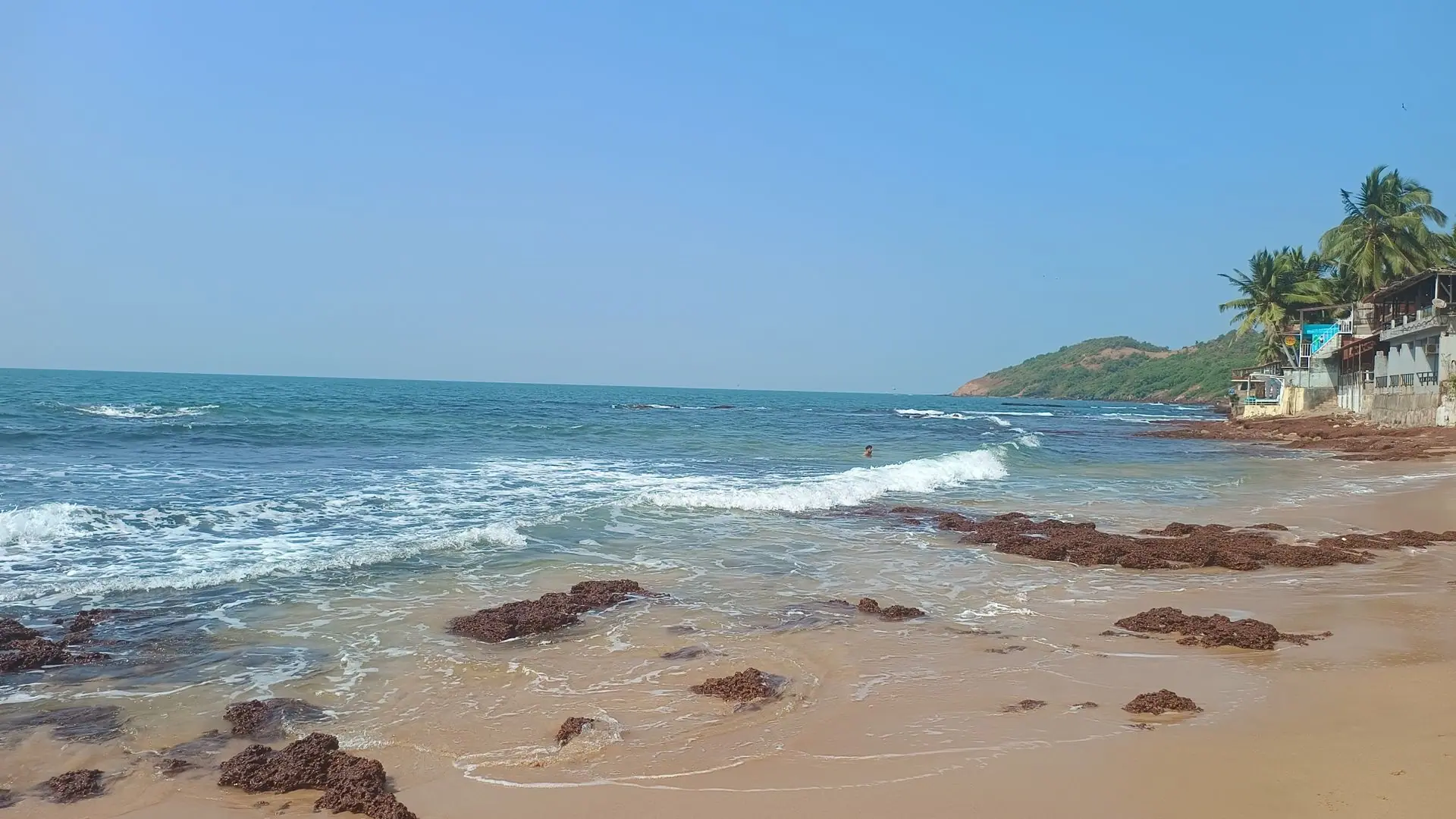 Beautiful Anjuna Beach in Goa with waves and clear skies