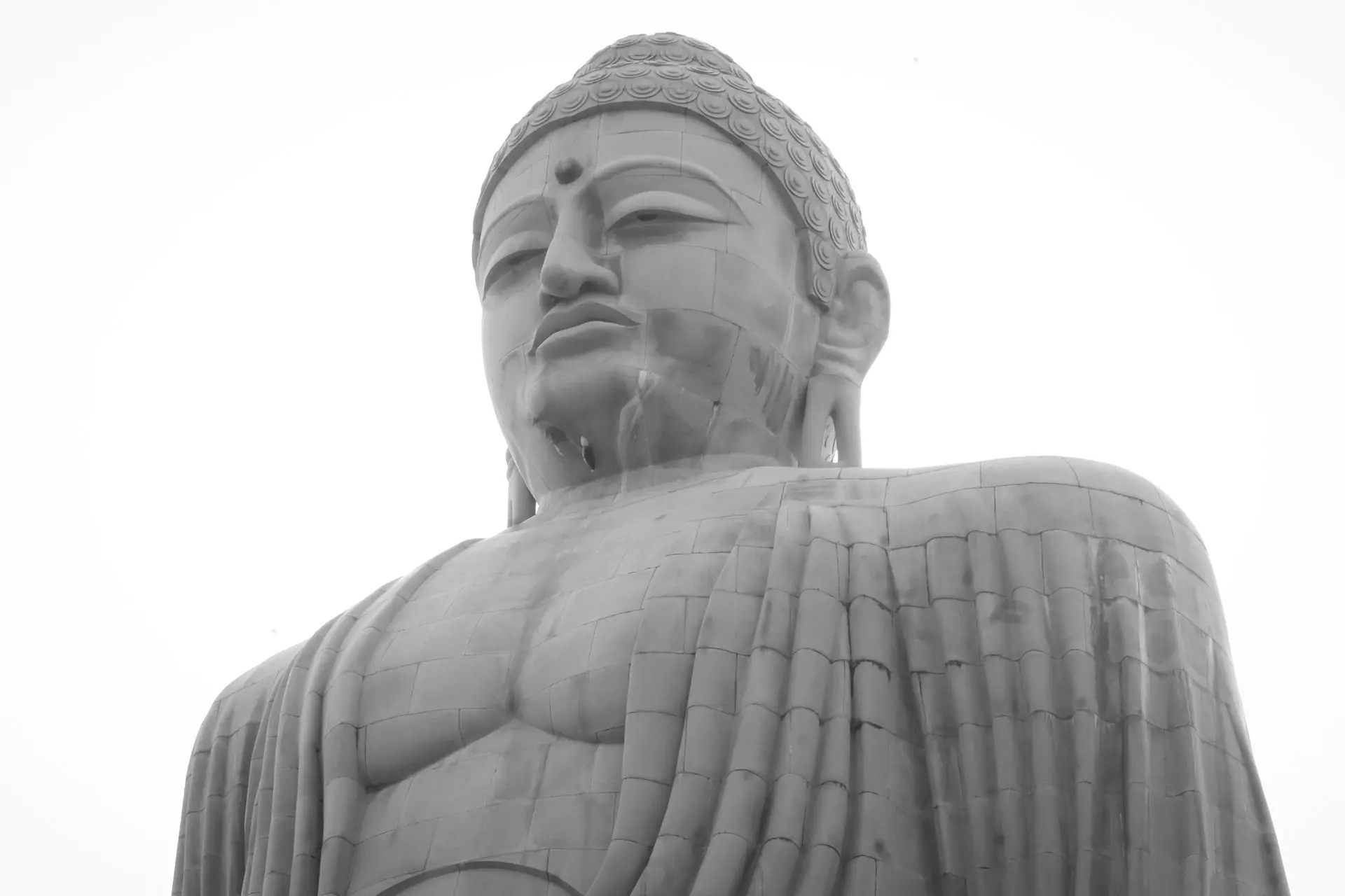 Striking black and white image of the giant Buddha statue in Bodh Gaya, symbolic of peace and spirituality