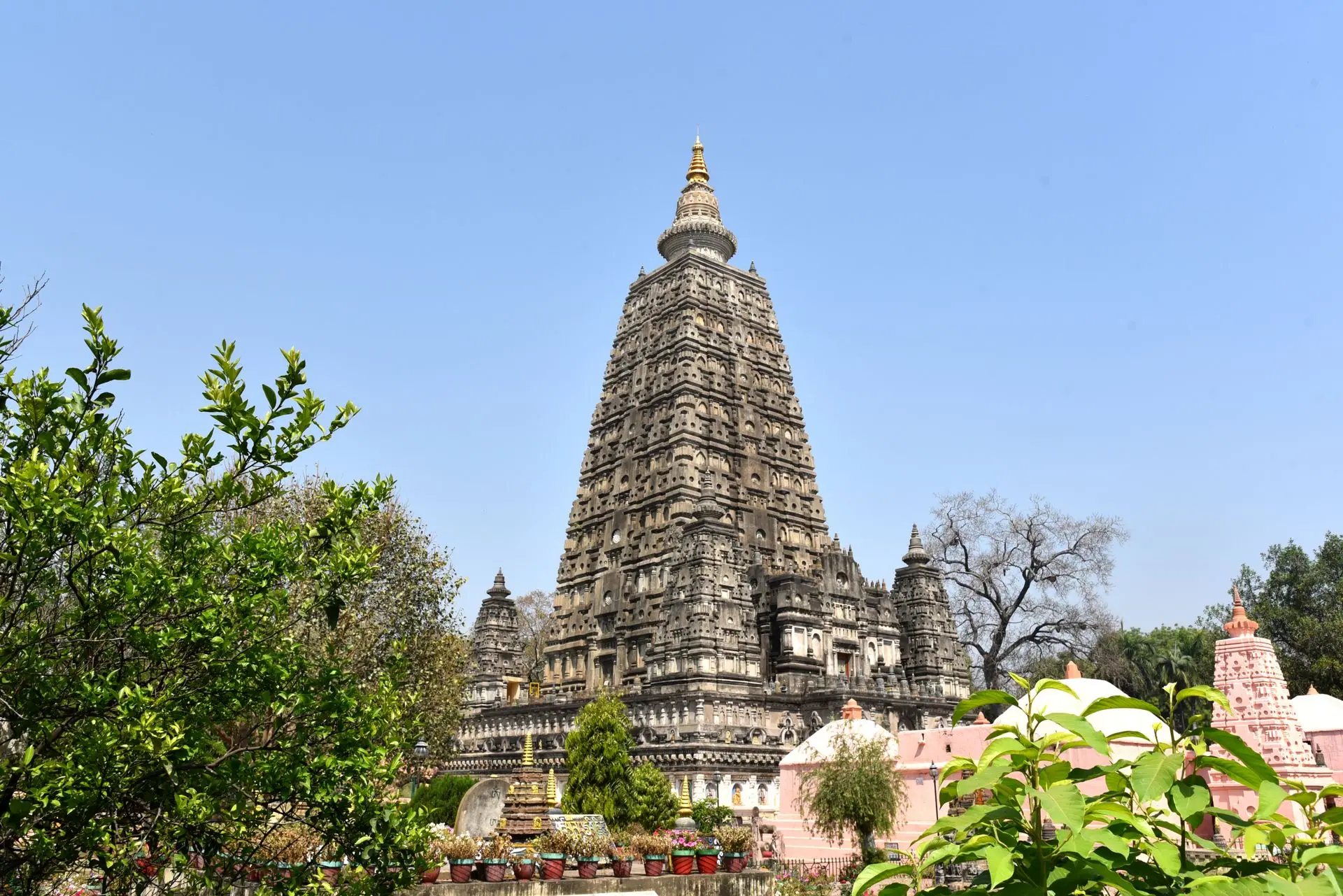 A stunning view of the Mahabodhi Temple in Bodh Gaya, India, surrounded by lush greenery