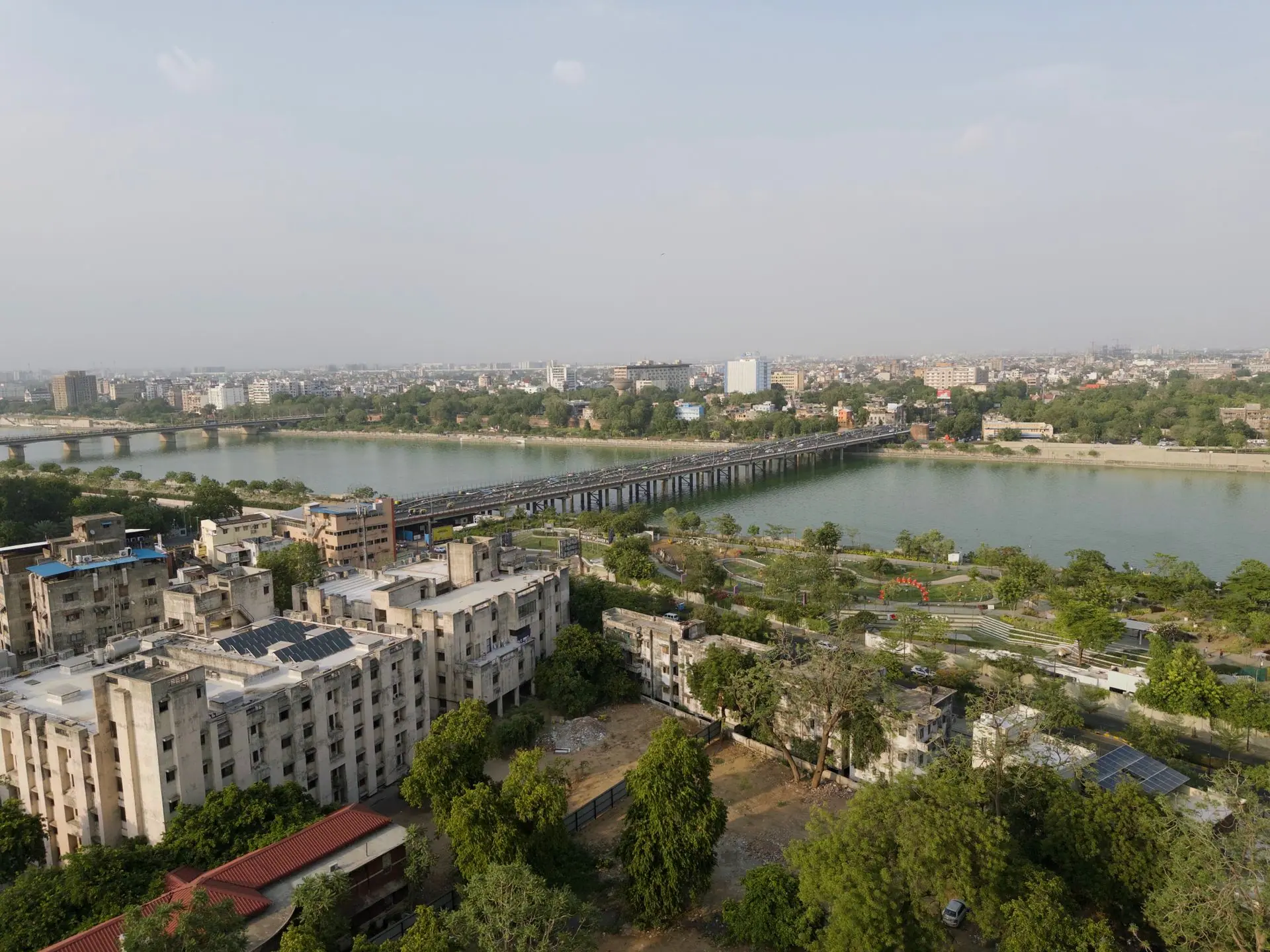 Aerial view of Ahmedabad showcasing the Sabarmati River and city skyline under a clear sky