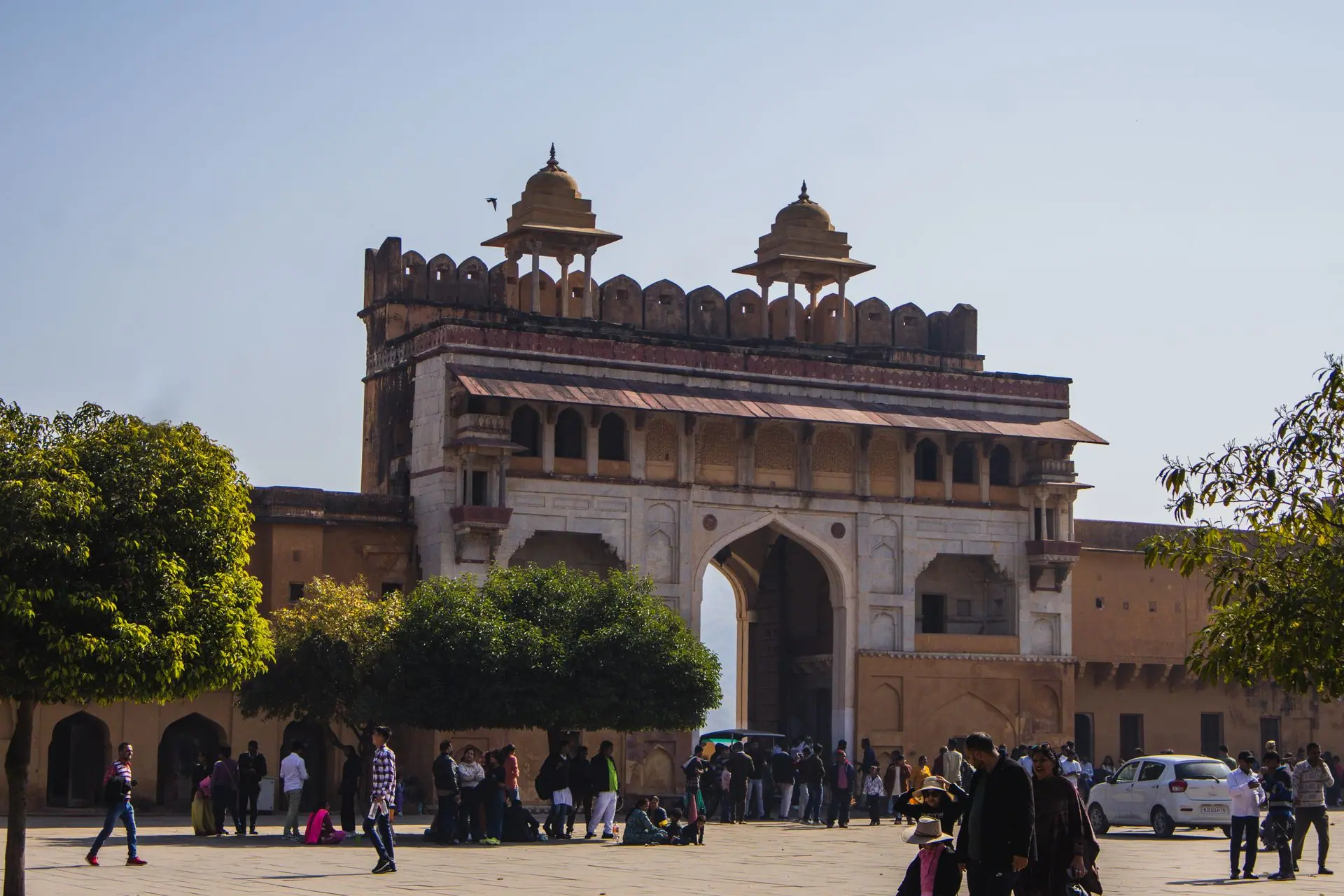 Photo of Amber Fort gate bustling with tourists under a clear blue sky