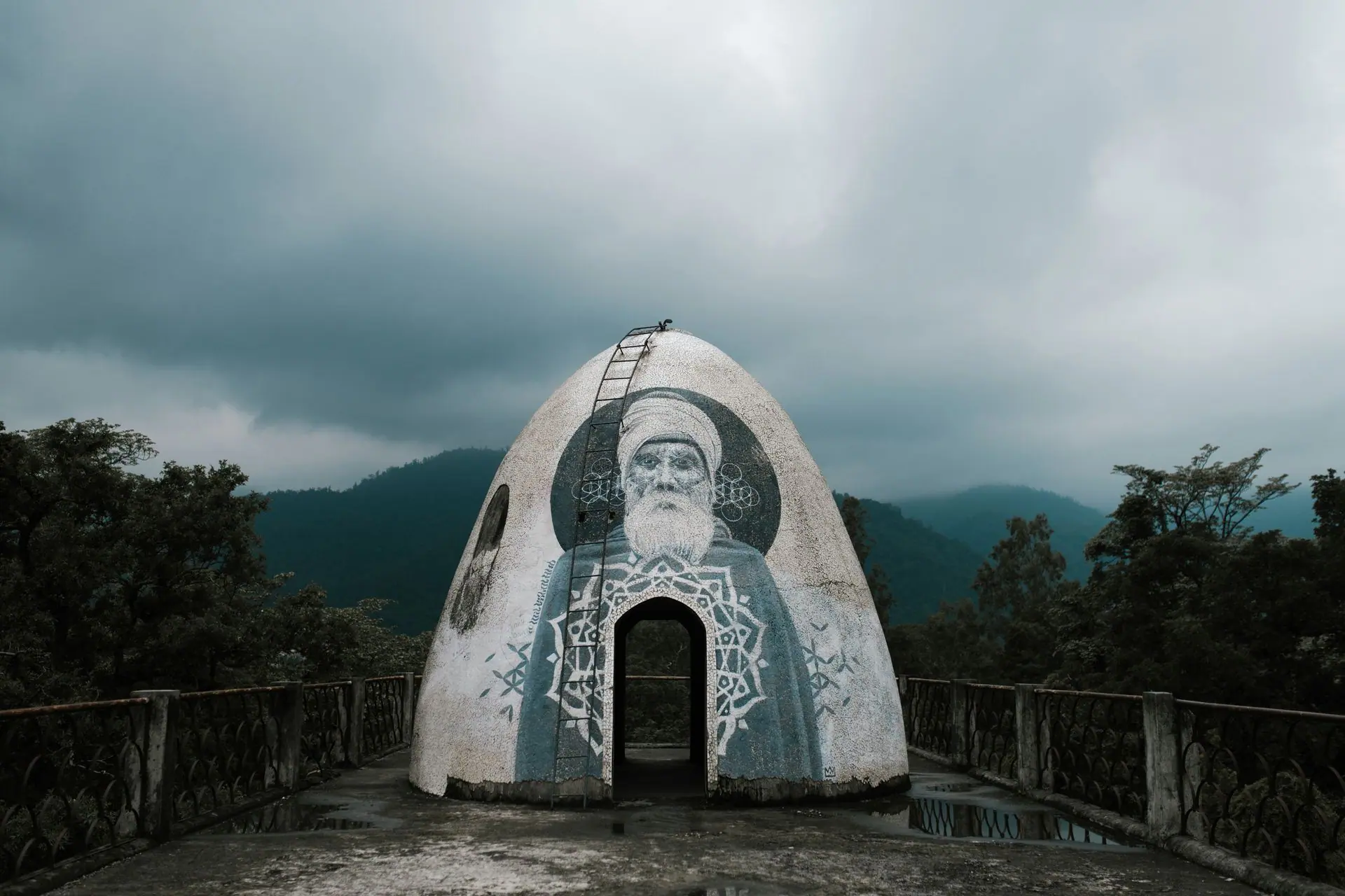 Rooftop meditation dome with graffiti located in Beatles Ashram against picturesque cloudy sky in mountains in Rishikesh