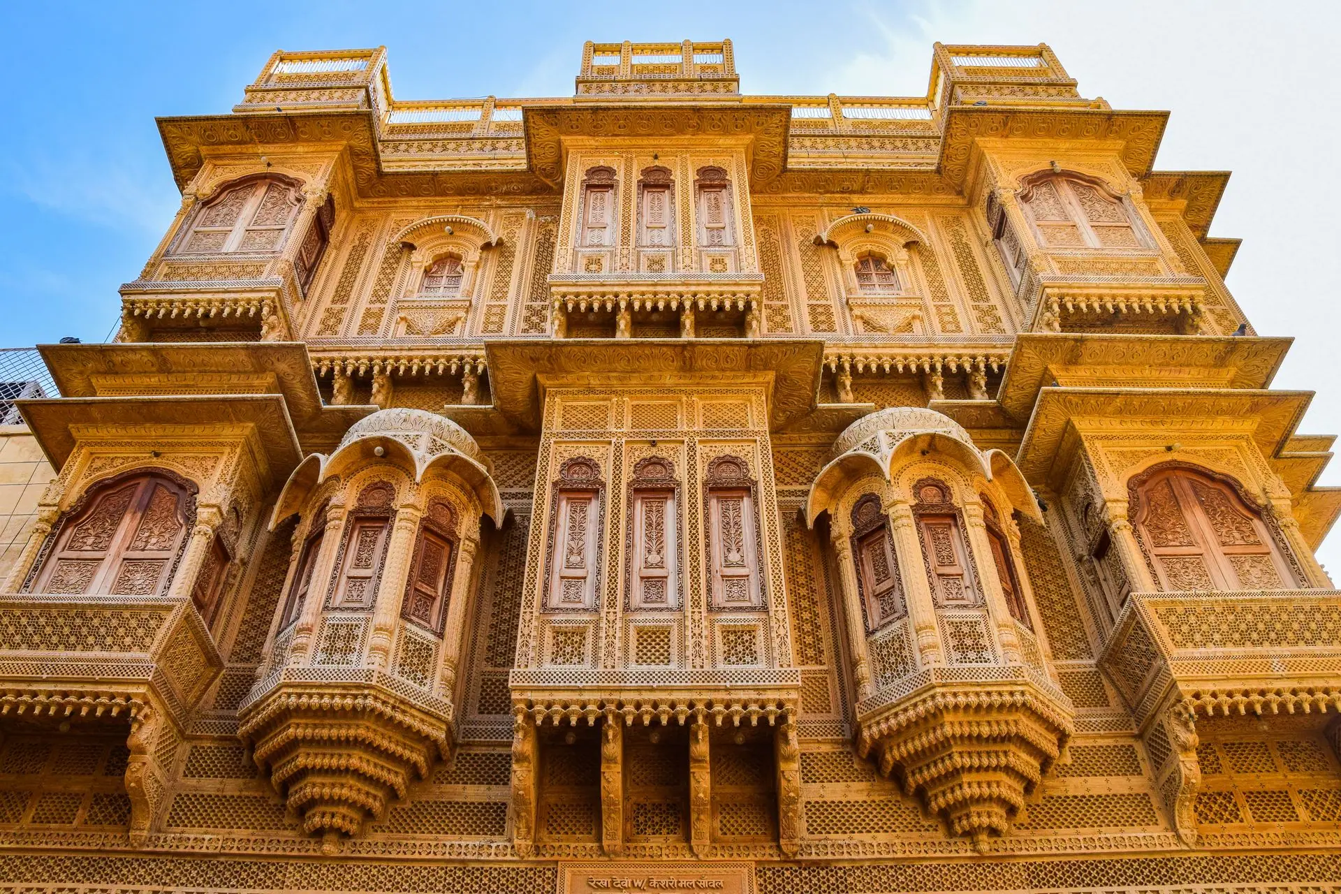 Intricate traditional Indian haveli facade captured under bright sunlight, showcasing ornate architecture