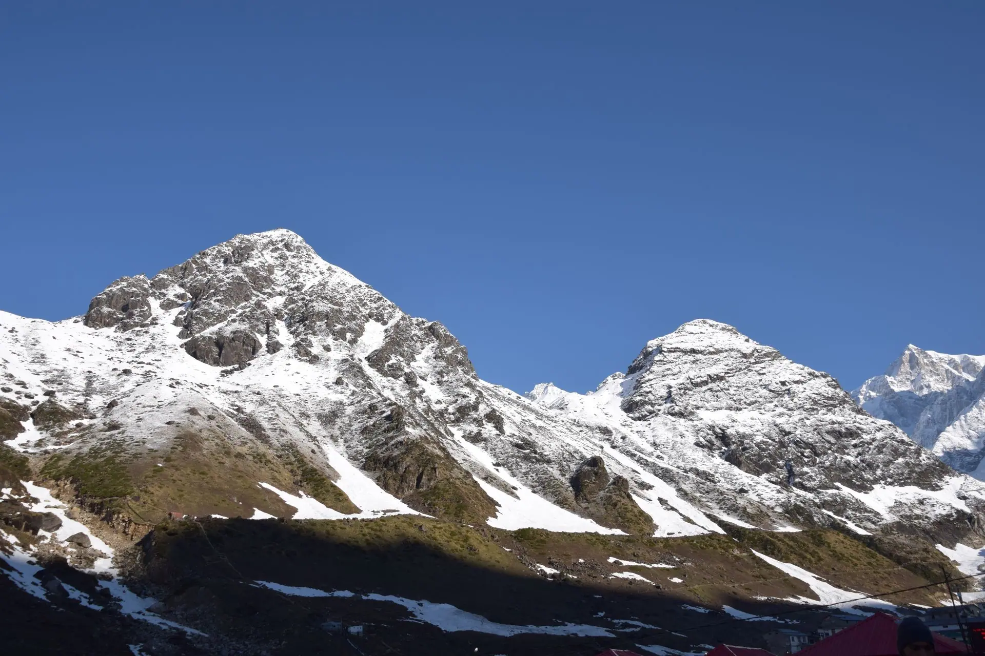 Breathtaking view of snowcapped mountains in Kedarnath, India under a clear blue sky