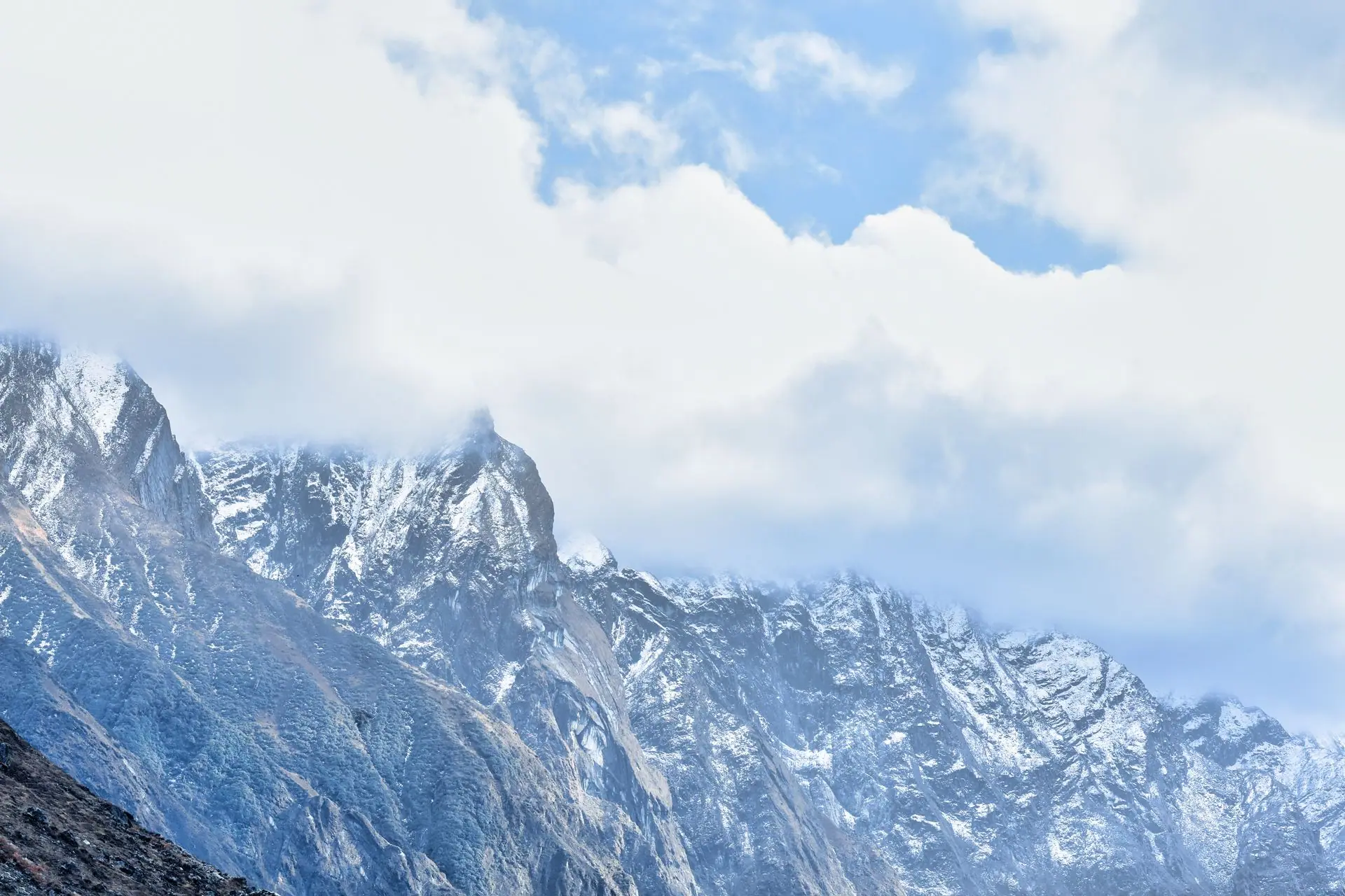 Majestic snow-covered mountains of Kedarnath, India, under a cloudy sky, showcasing natural beauty and rugged terrain