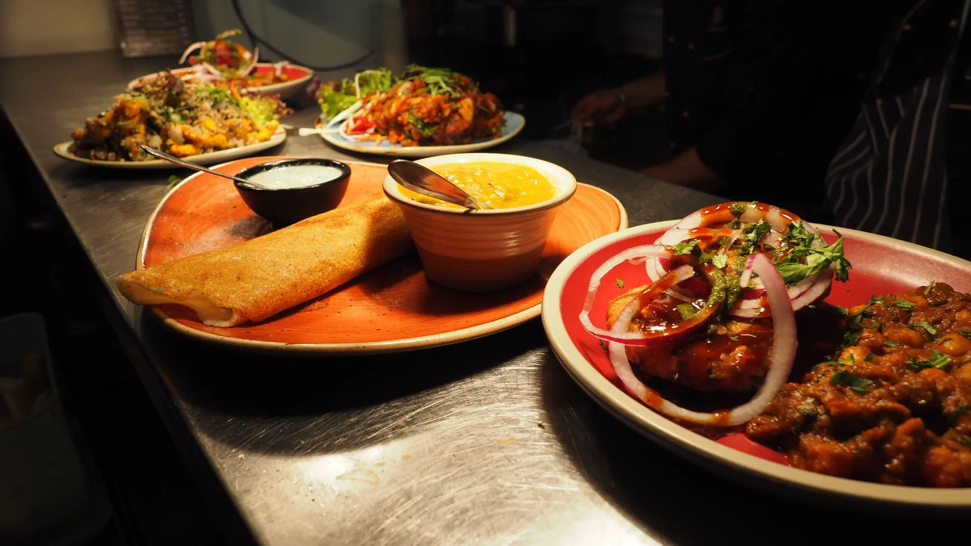 A tantalizing array of Indian dishes including dosa, curry, and chutney served on vibrant plates