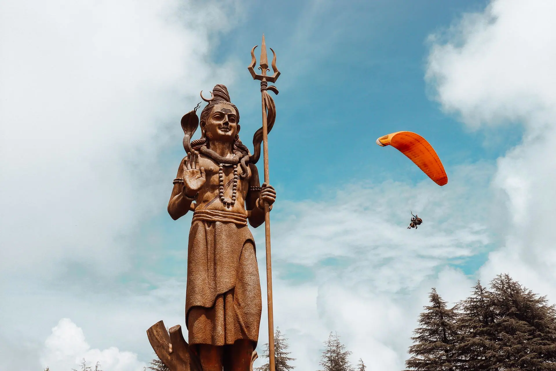 Majestic statue of Shiva with paraglider in sky, Dalhousie, India