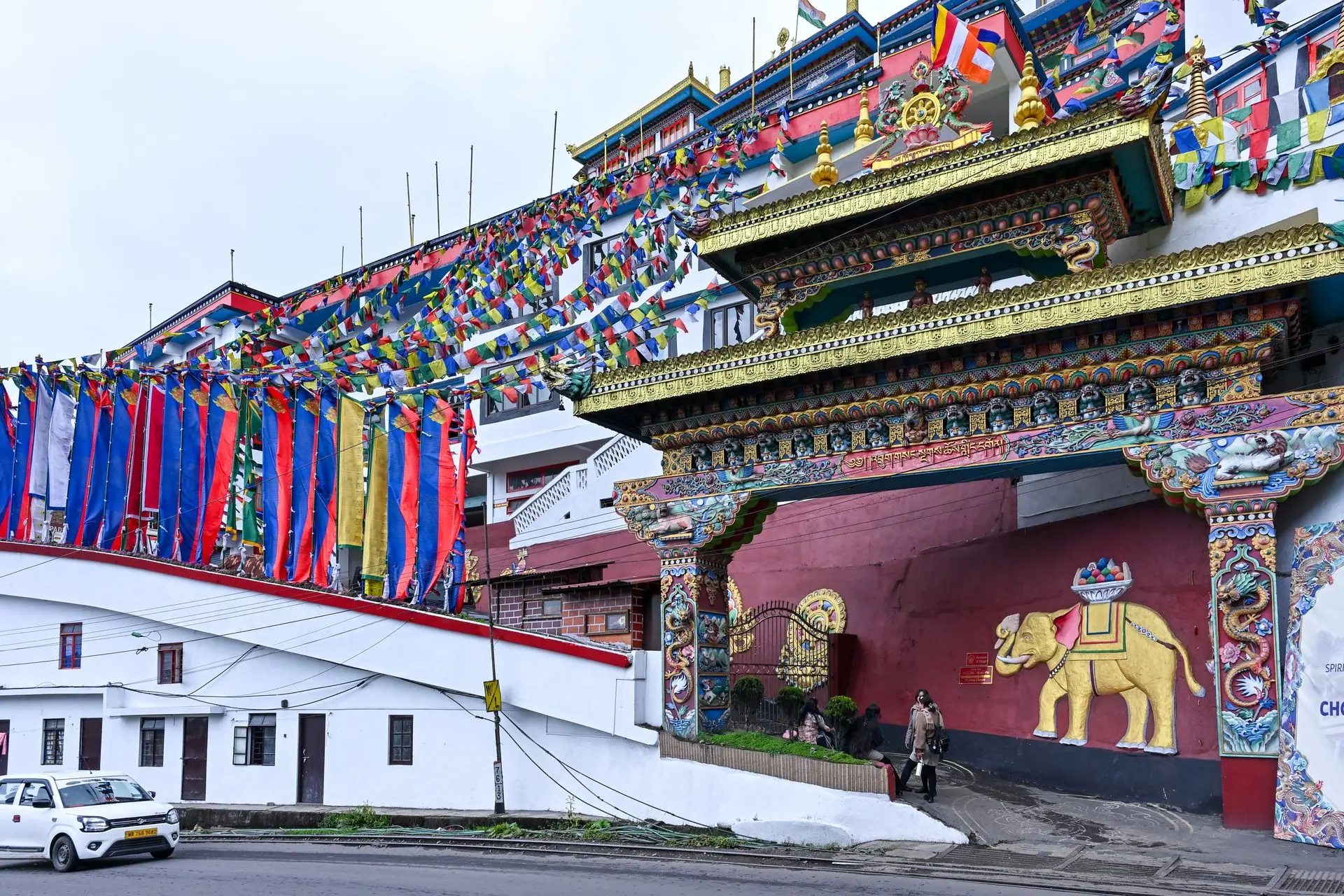 Explore the vibrant Tibetan architecture of a monastery in Darjeeling, India, adorned with prayer flags