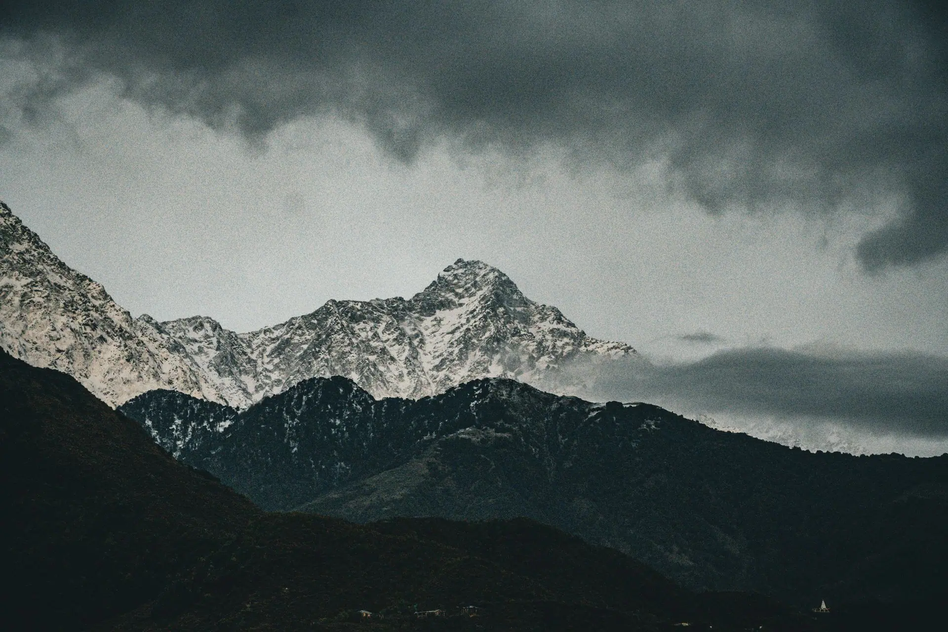 Snow-capped peaks of the Himalayas under moody skies in Dharamshala, Himachal Pradesh, India