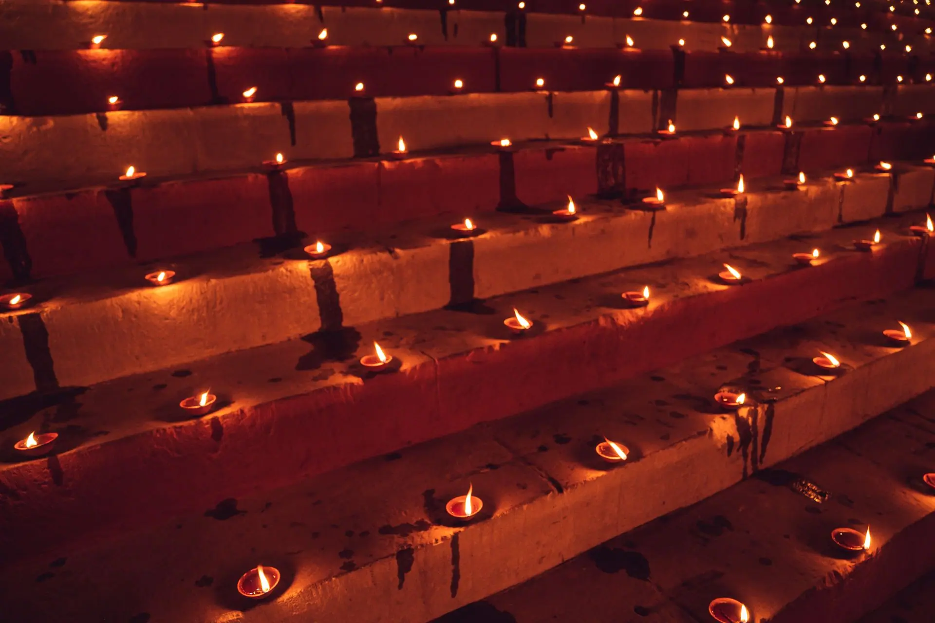 Rows of oil lamps illuminate steps during Diwali, highlighting traditional Indian culture
