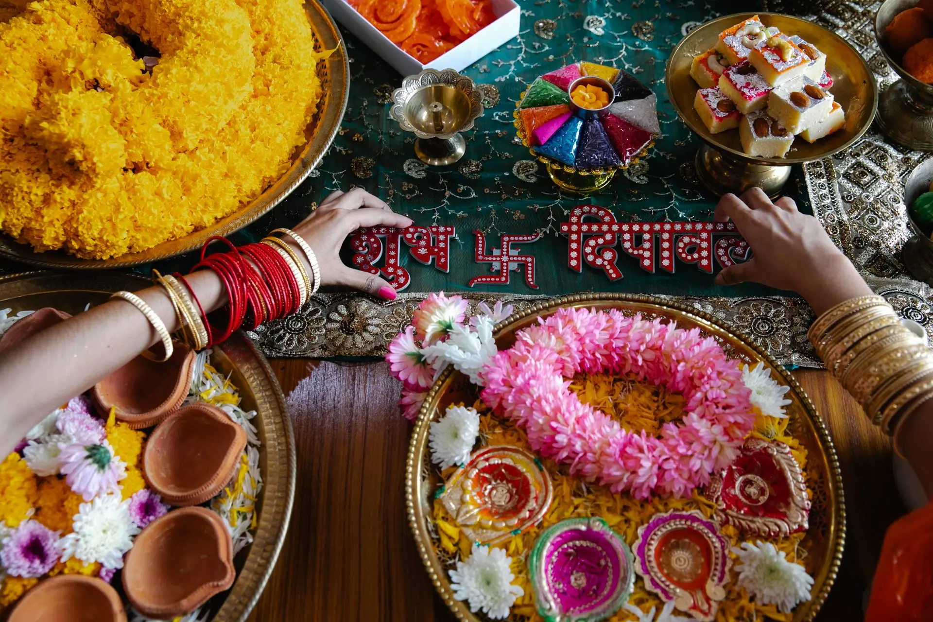 Celebratory Diwali table adorned with flowers, garlands, and traditional Indian sweets