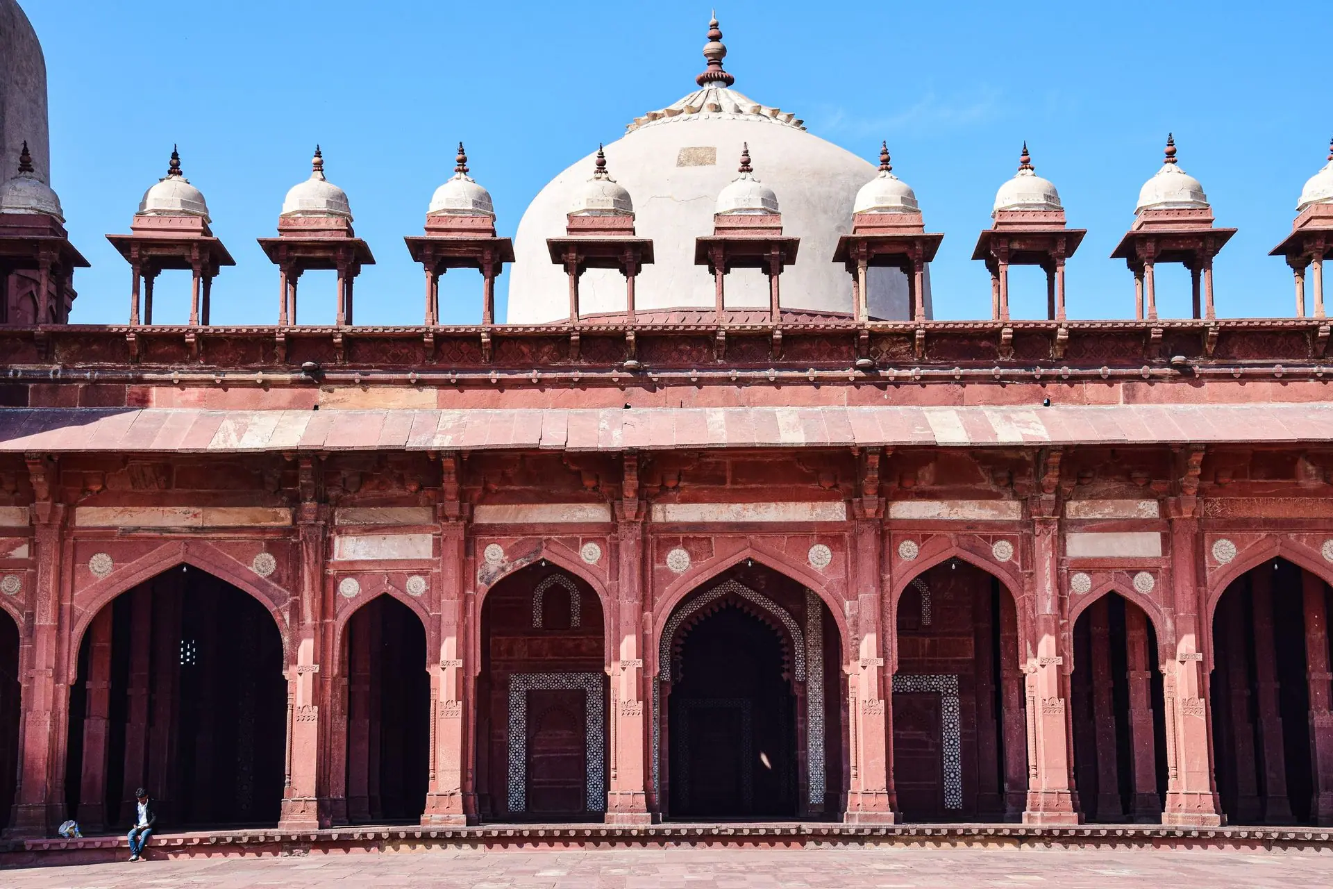 Elegant arches and domes of Jama Masjid in Fatehpur Sikri, India, captured under a clear blue sky