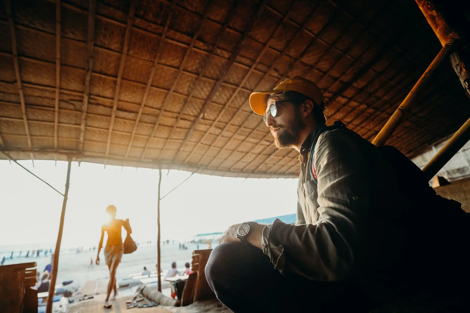 Man under a sunshade at the beach enjoying summer vibes in Goa, India