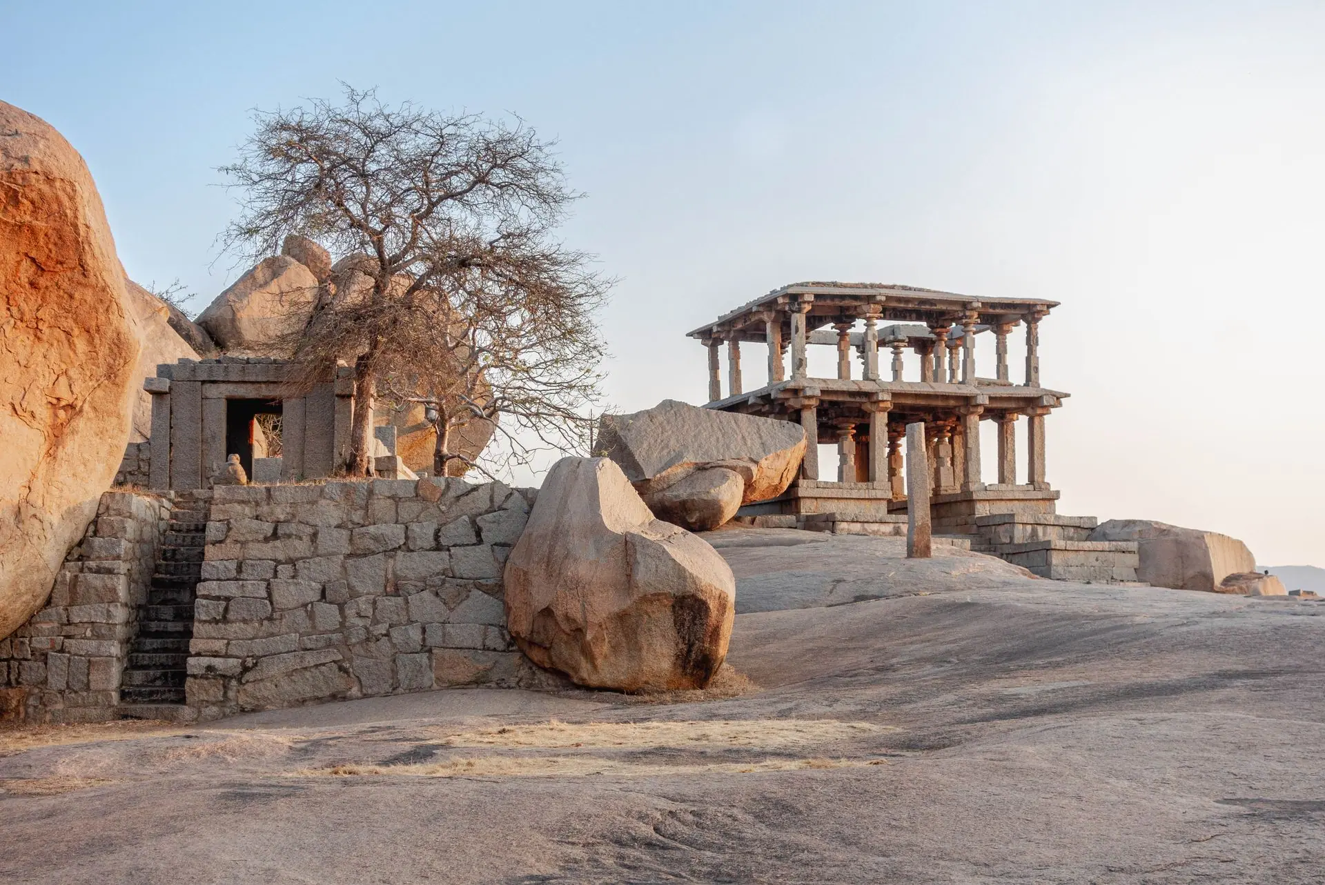 Historic stone structures and boulders at sunrise in Hampi, Karnataka, India