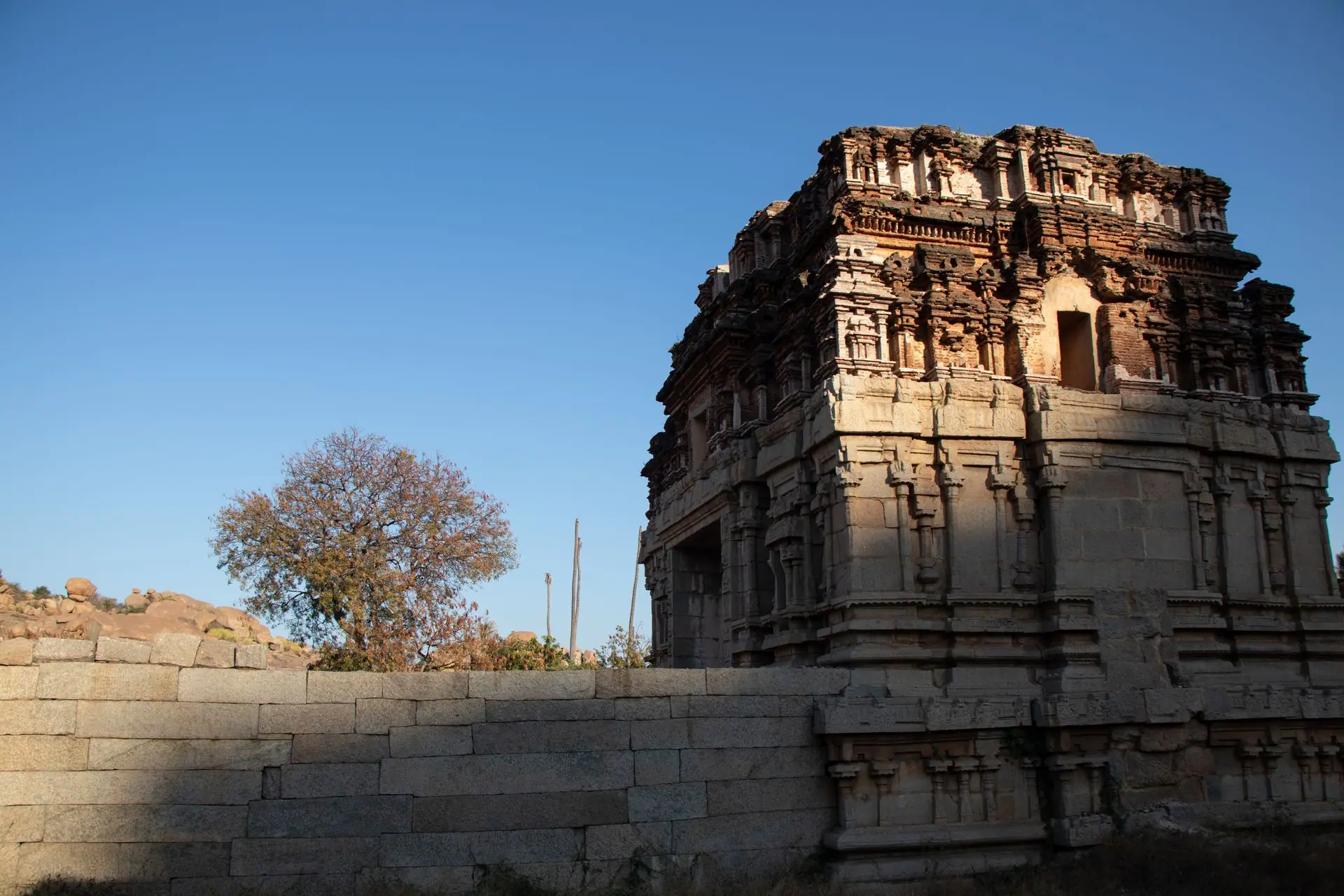 Explore the ancient architectural beauty of a temple ruin in Hampi, India, under a clear blue sky
