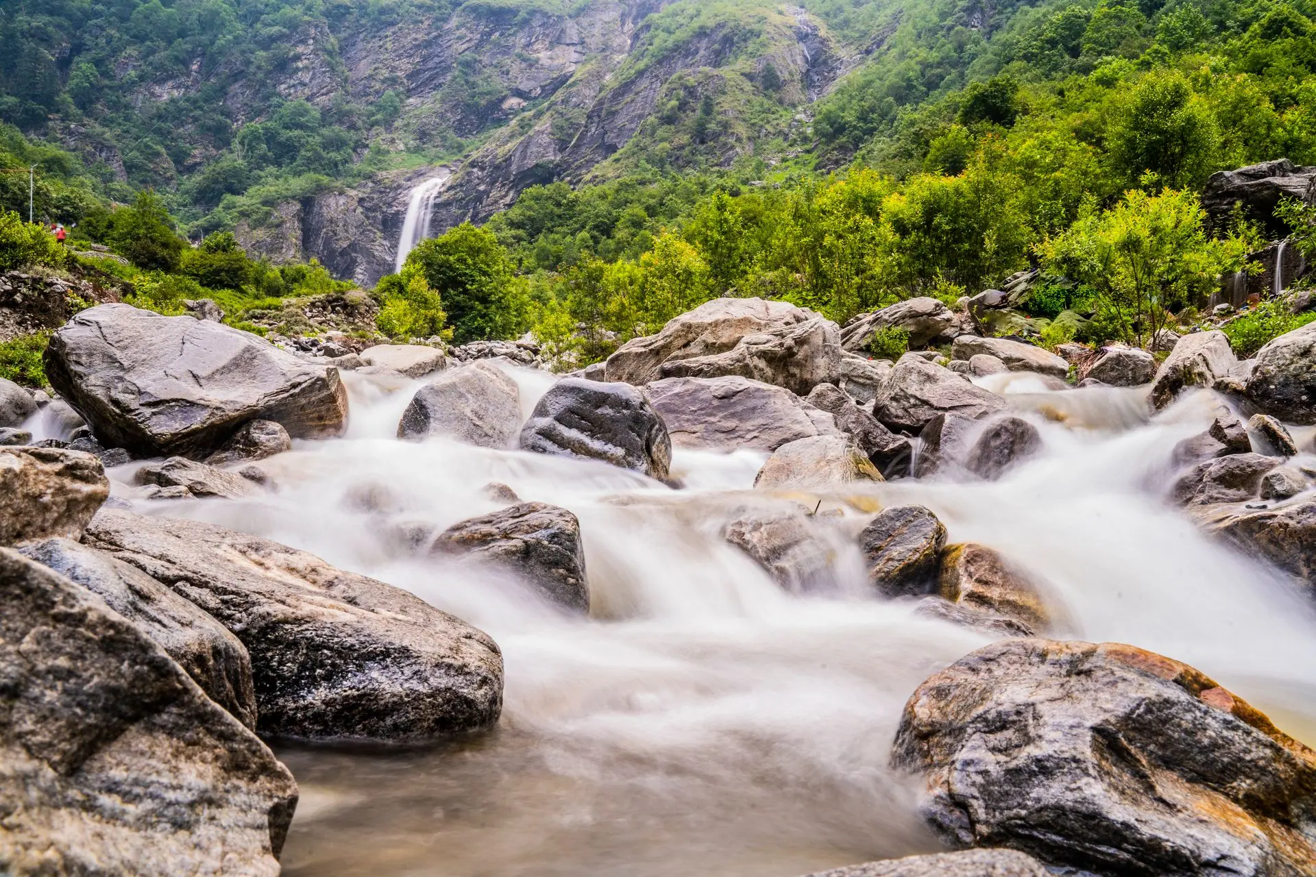 A beautiful waterfall cascading through rocky terrain in Haridwar, India, surrounded by lush greenery