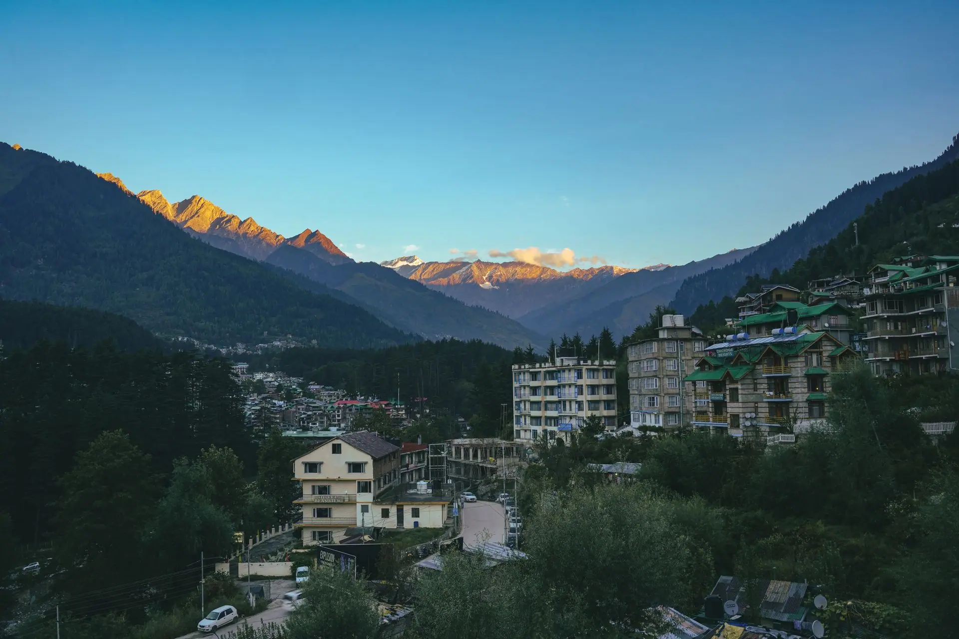 Breathtaking view of Manali town with the Himalayan mountains glowing at sunset in Himachal Pradesh, India