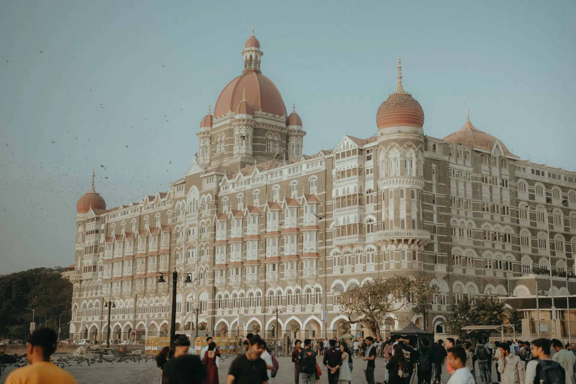 Capture of The Taj Mahal Palace Hotel in Mumbai, India with people in the foreground at twilight