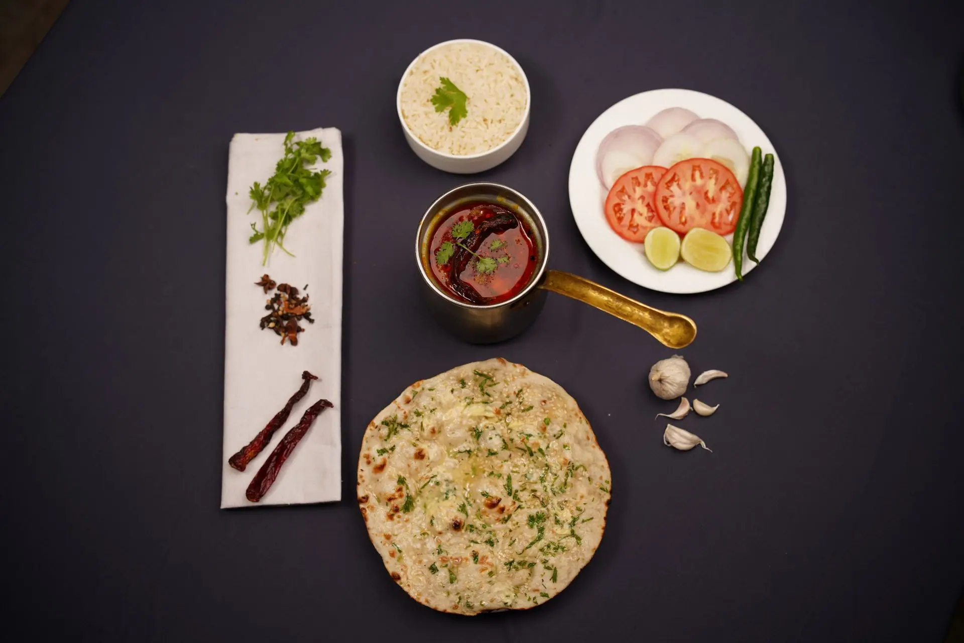 A delicious arrangement of Indian cuisine featuring lachha bread and rich curry