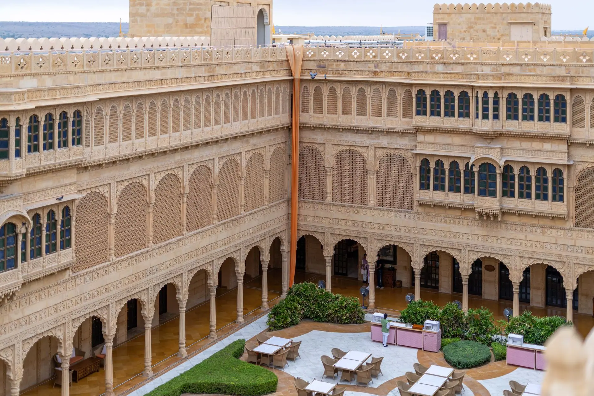 Explore the intricate sandstone architecture of a Jaisalmer heritage hotel courtyard