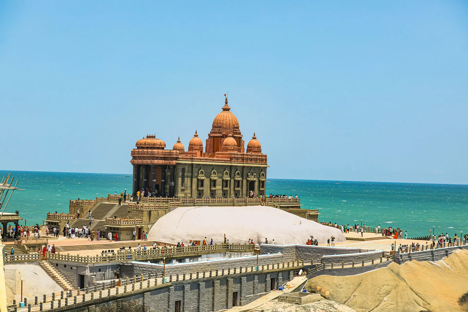 Vivekananda Rock Memorial by the sea in Kanyakumari with tourists enjoying the sunny day