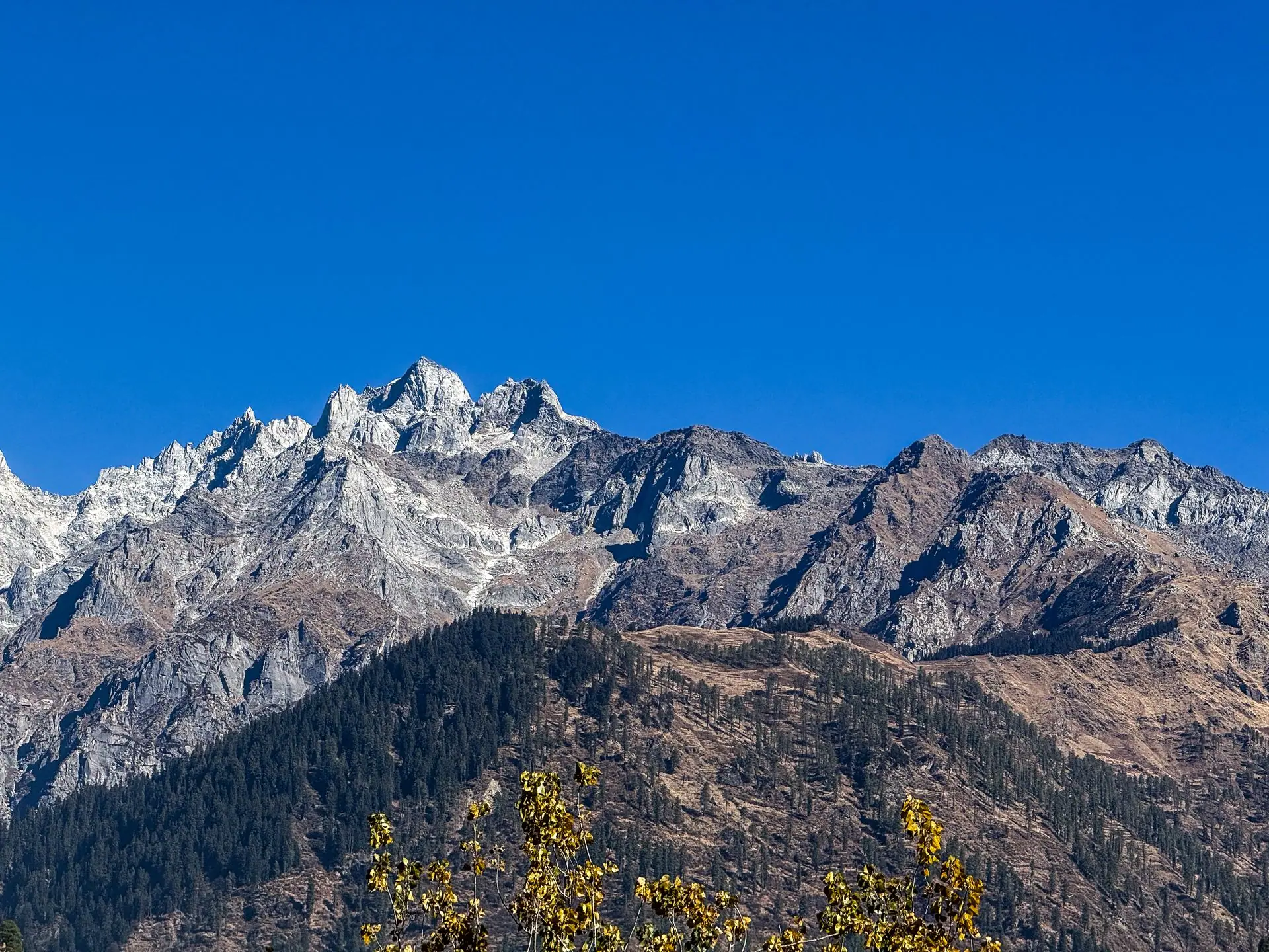 Stunning view of the rugged mountains under a clear blue sky in Kasol, Himachal Pradesh