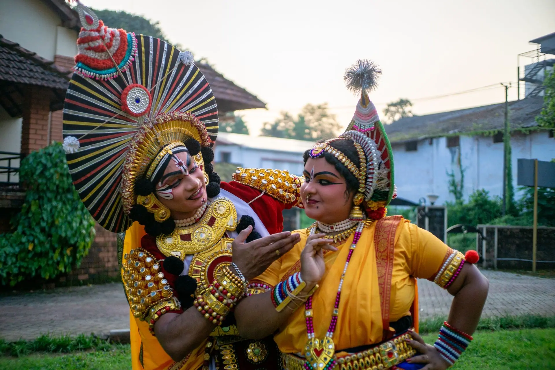 Colorful Kathakali dancers in traditional attire performing in an outdoor setting