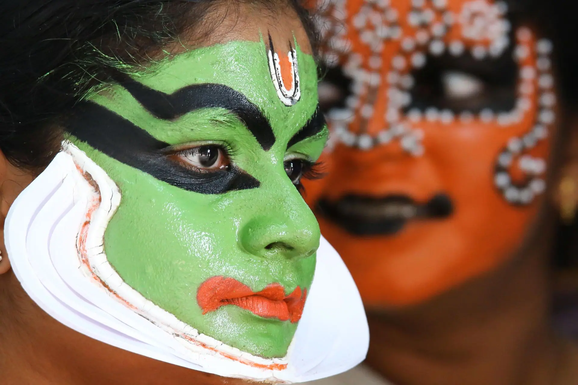 Vibrant close-up of a Kathakali dancer showcasing traditional face paint in vivid colors. Cultural performance art