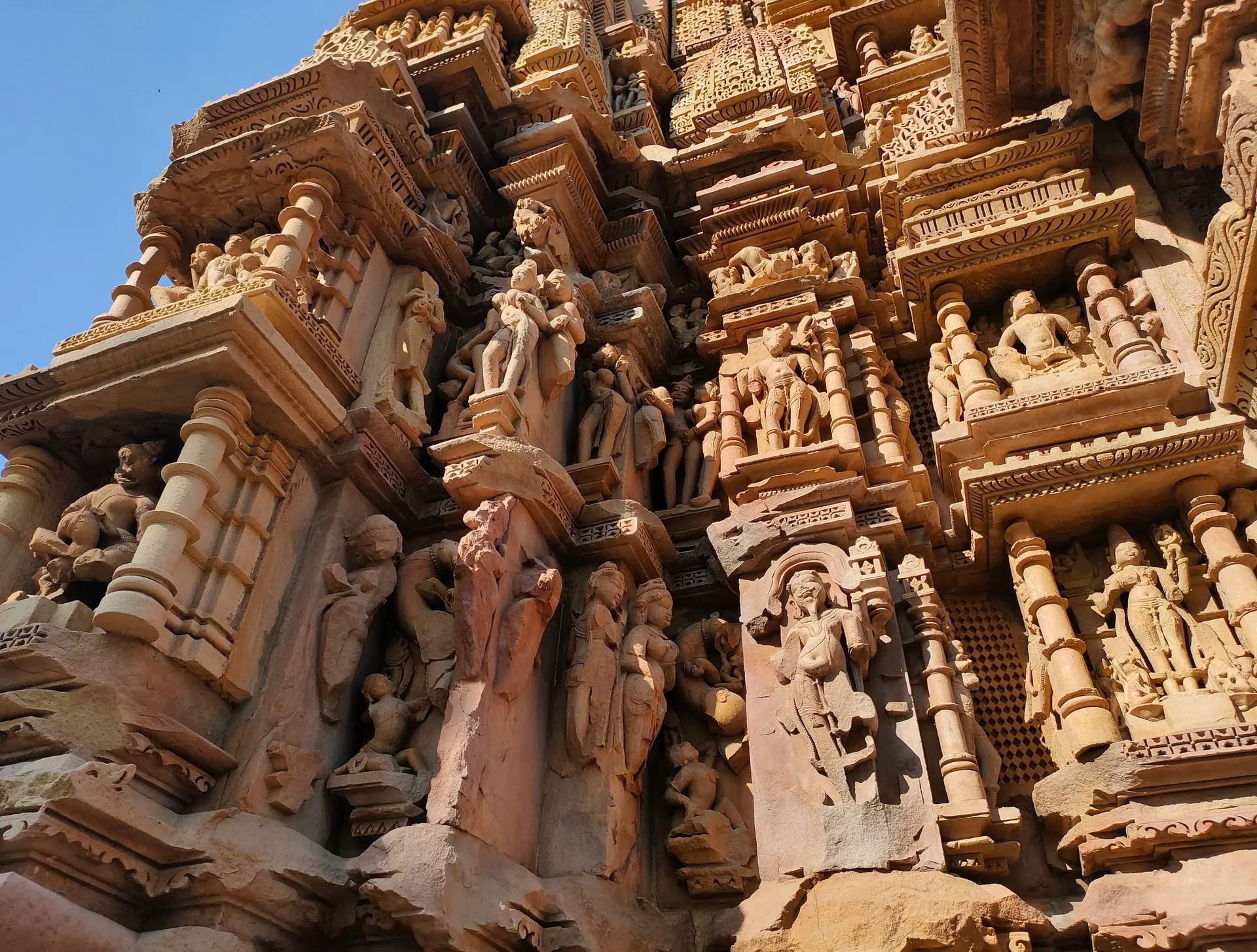 Detailed stone carvings on a temple facade in Khajuraho, India showcasing ancient Indian artistry