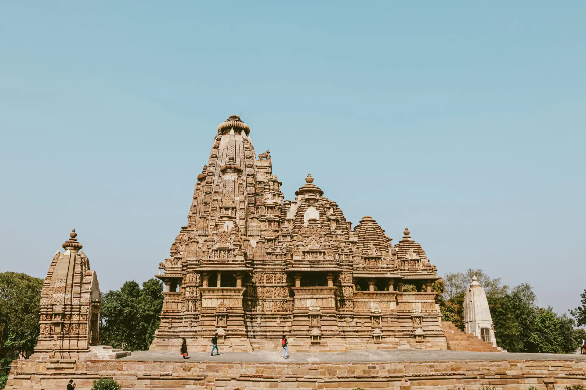 Exterior of Lakshmana Temple located in Khajuraho India against trees and clear blue sky
