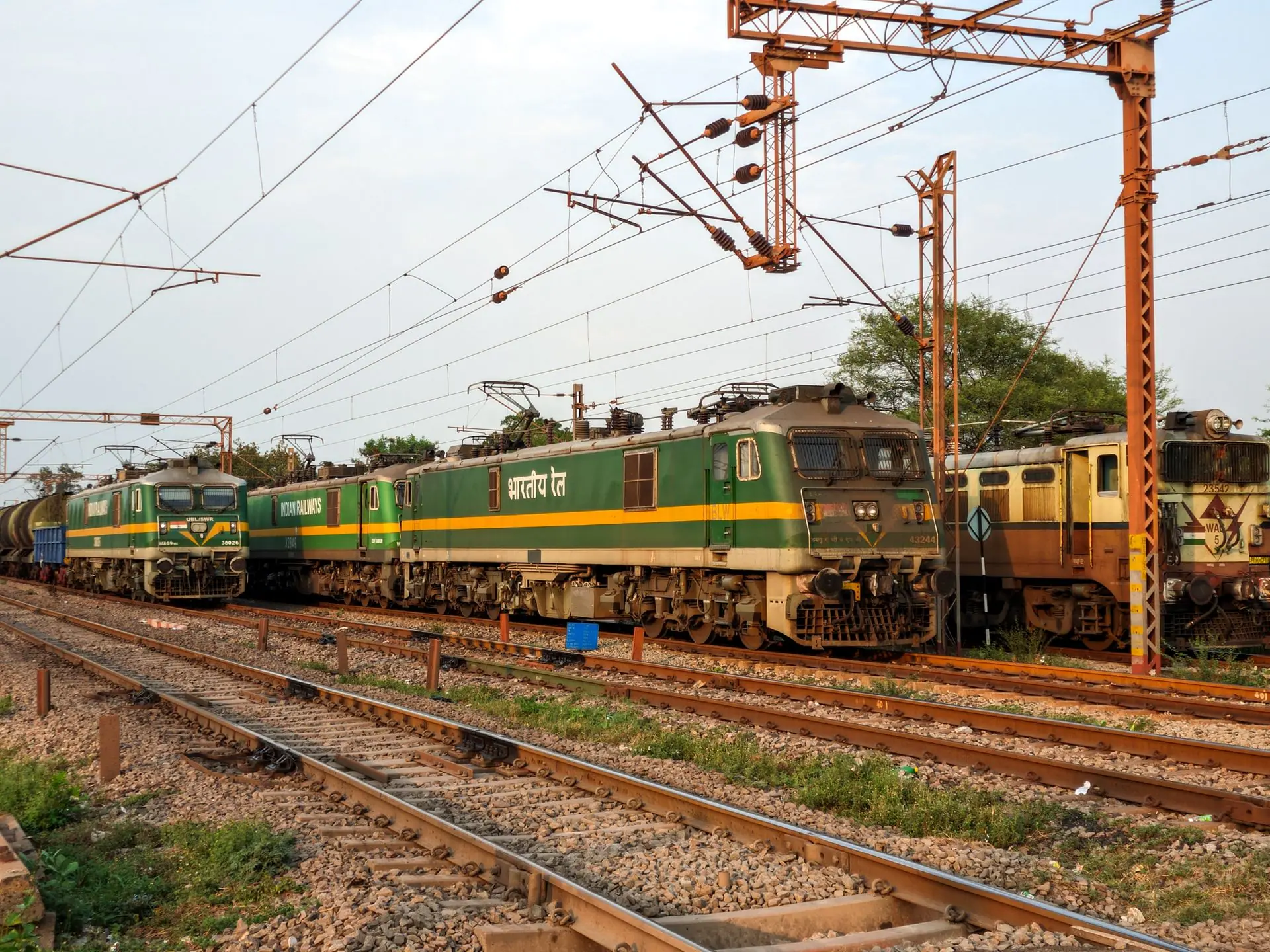 Electric locomotives of Indian Railways on tracks during sunset, showcasing the railway infrastructure