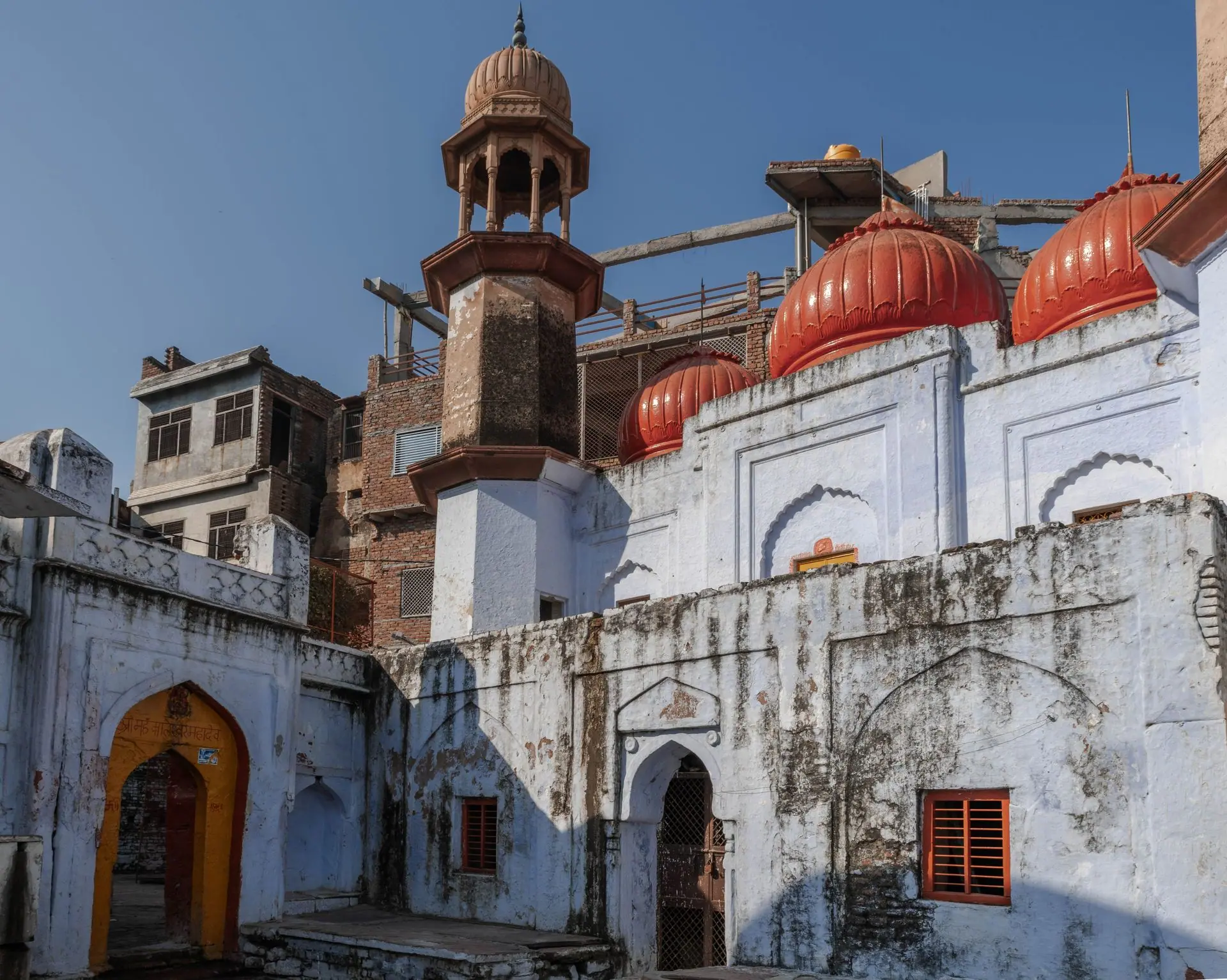 A view of a historic building with red domes and intricate design in Mathura, Uttar Pradesh, India