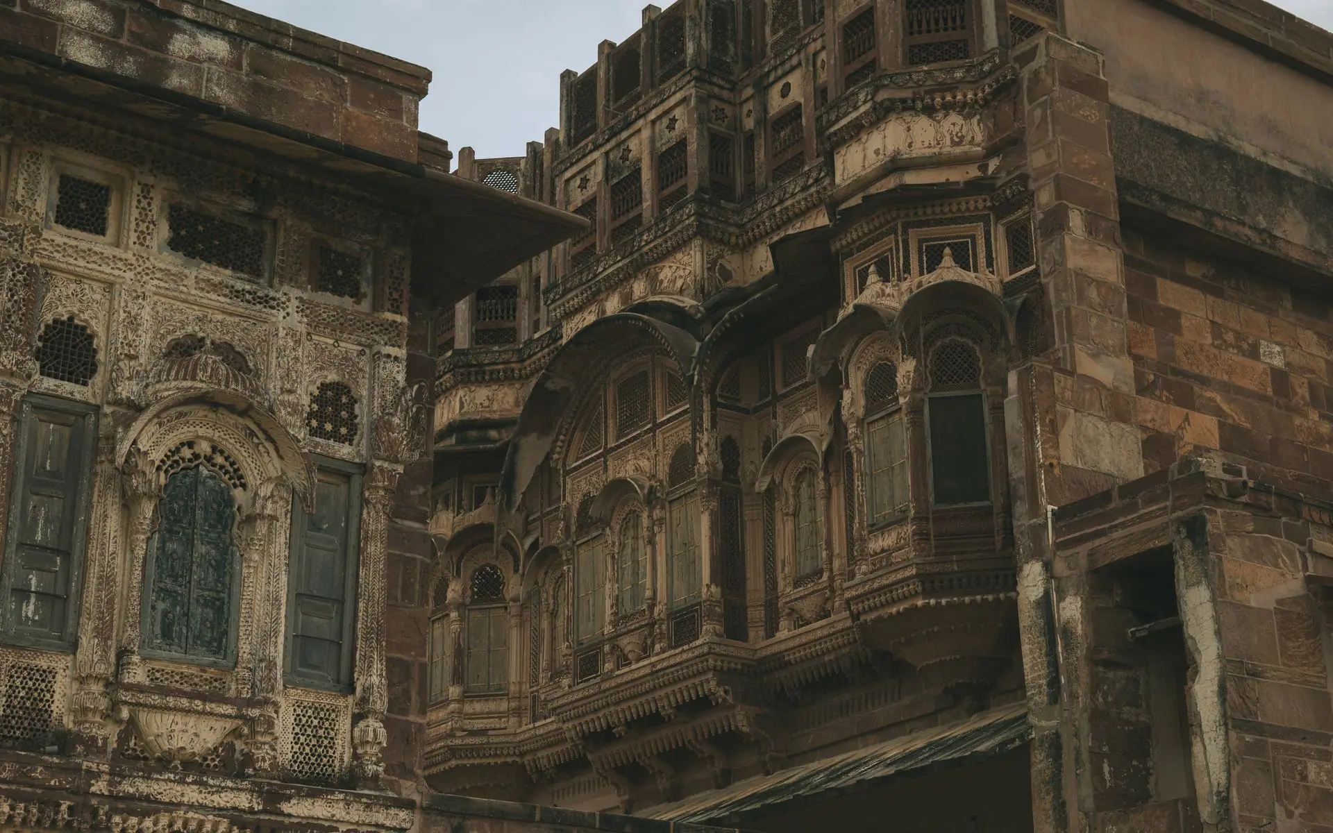 Ornate sandstone carvings and latticework adorn a historical building facade in Jodhpur, India