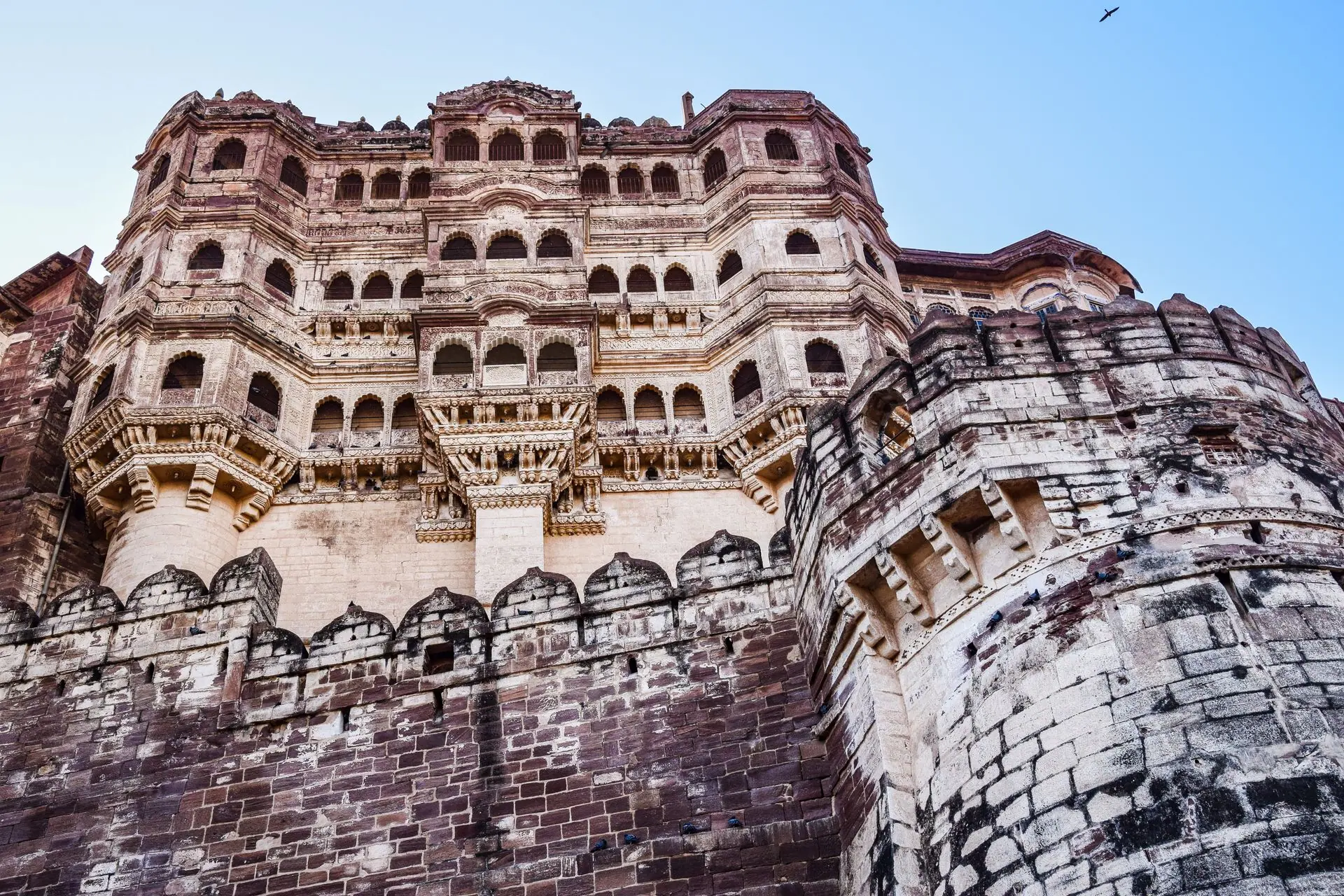 Impressive view of Mehrangarh Fort's detailed facade against clear blue sky, Jodhpur, India
