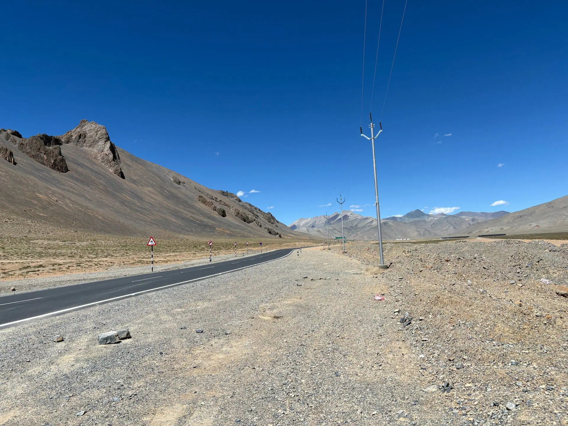Desolate road through the rocky mountains of Leh under a clear blue sky