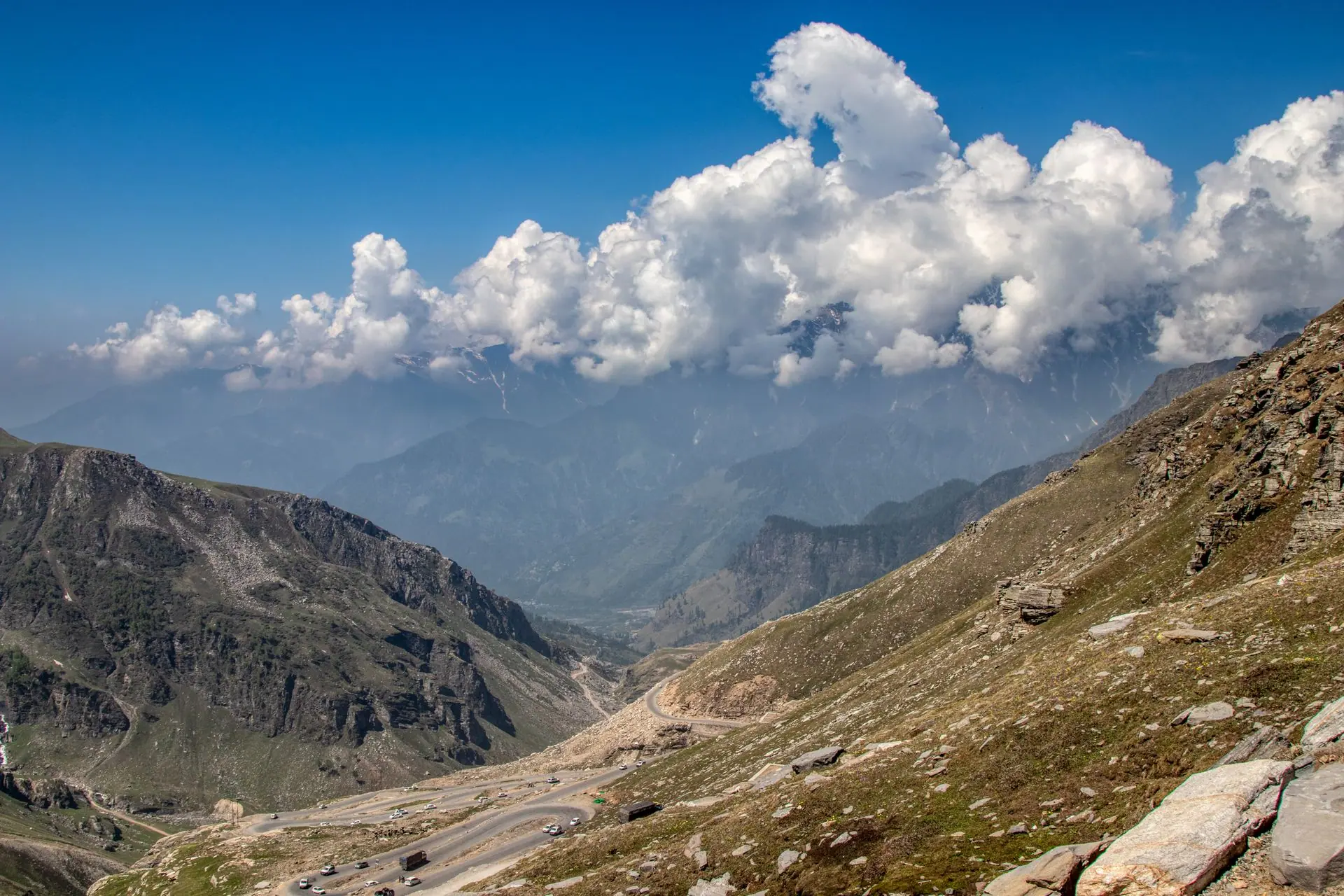 Stunning view of mountains and valleys in Manali, India, under a vivid blue sky with clouds