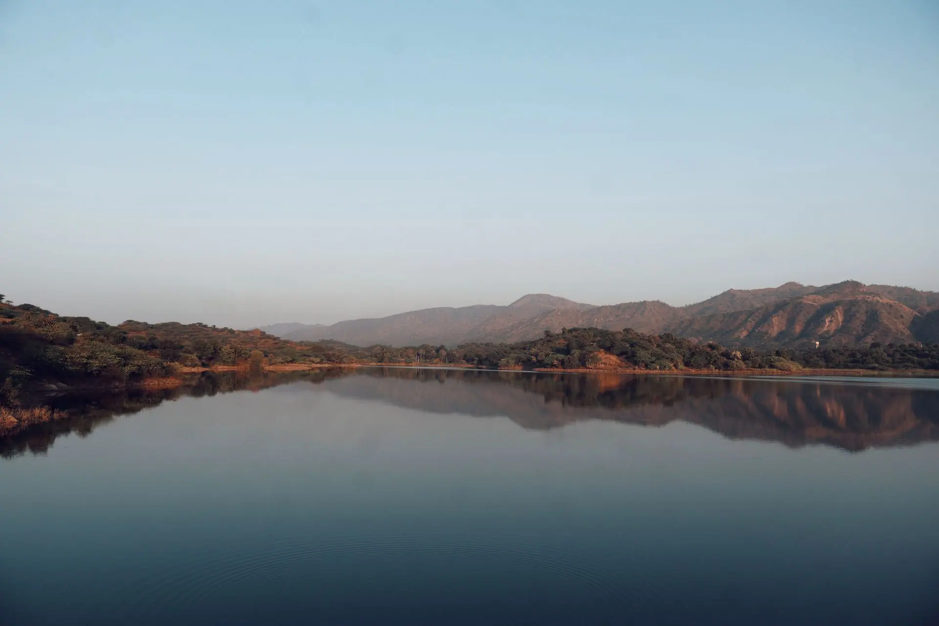 Serene lake with mountain reflections in Mount Abu, Rajasthan, India