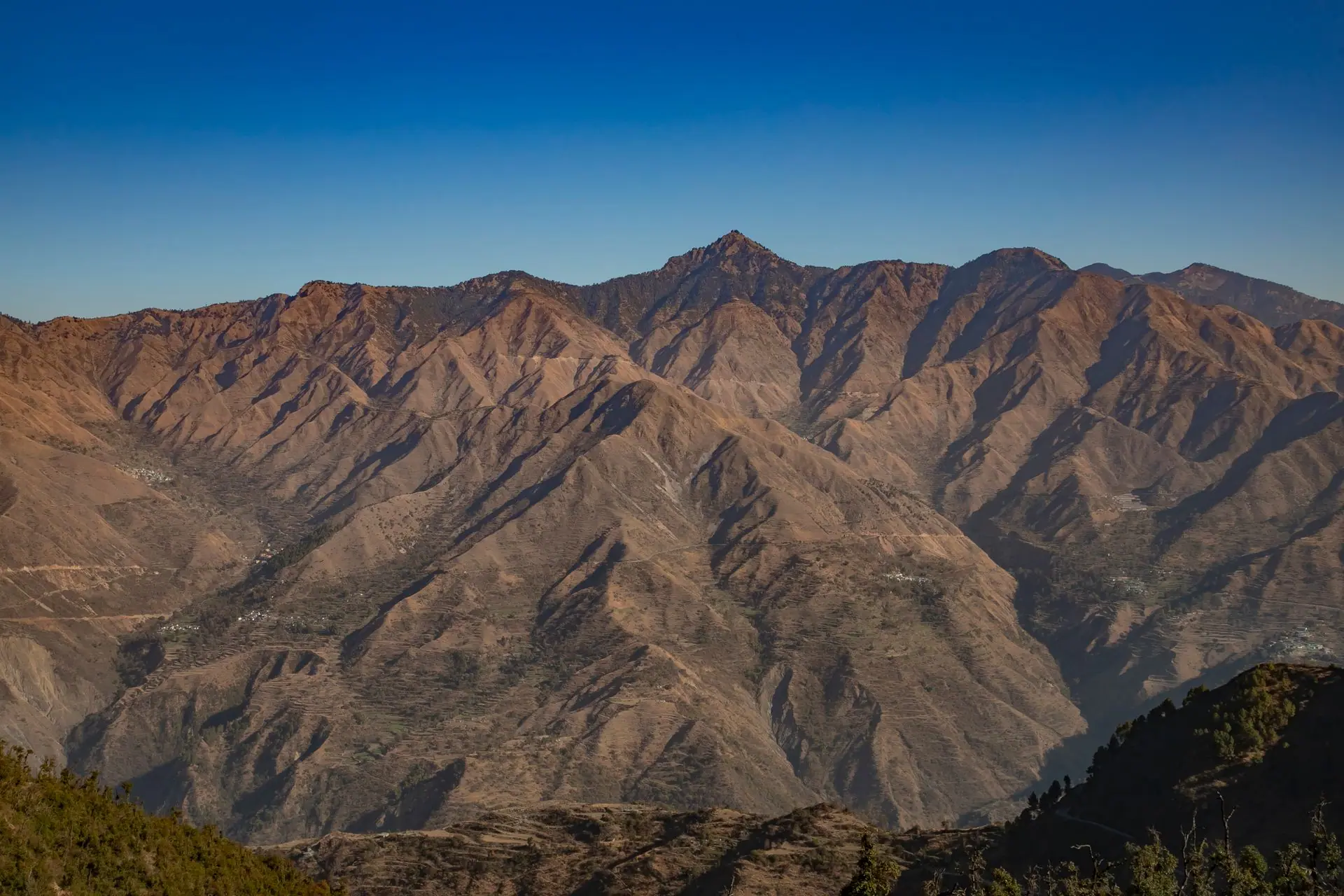 Breathtaking aerial view of the rugged mountain peaks near Mussoorie, India under clear blue skies