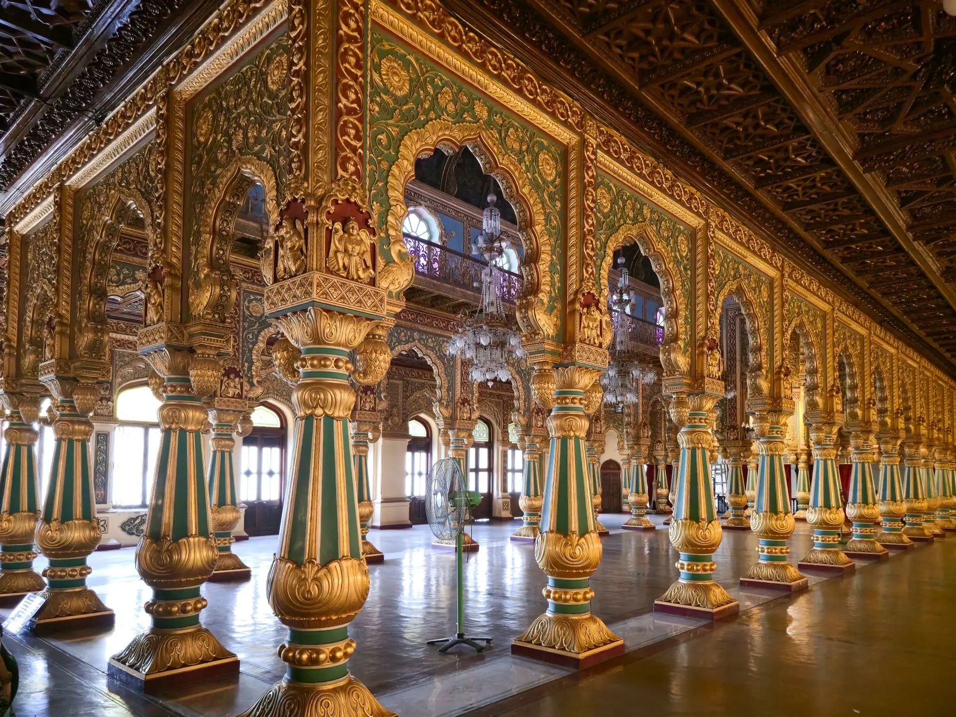 Intricate columns and arches in the opulent hall of Mysore Palace, showcasing detailed Indian architecture