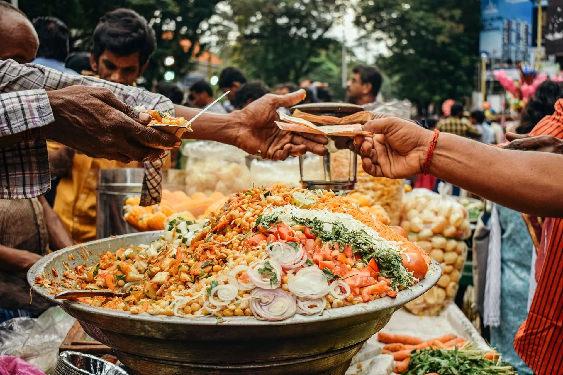 Colorful street food scene in India with vendor serving traditional snacks at a busy market
