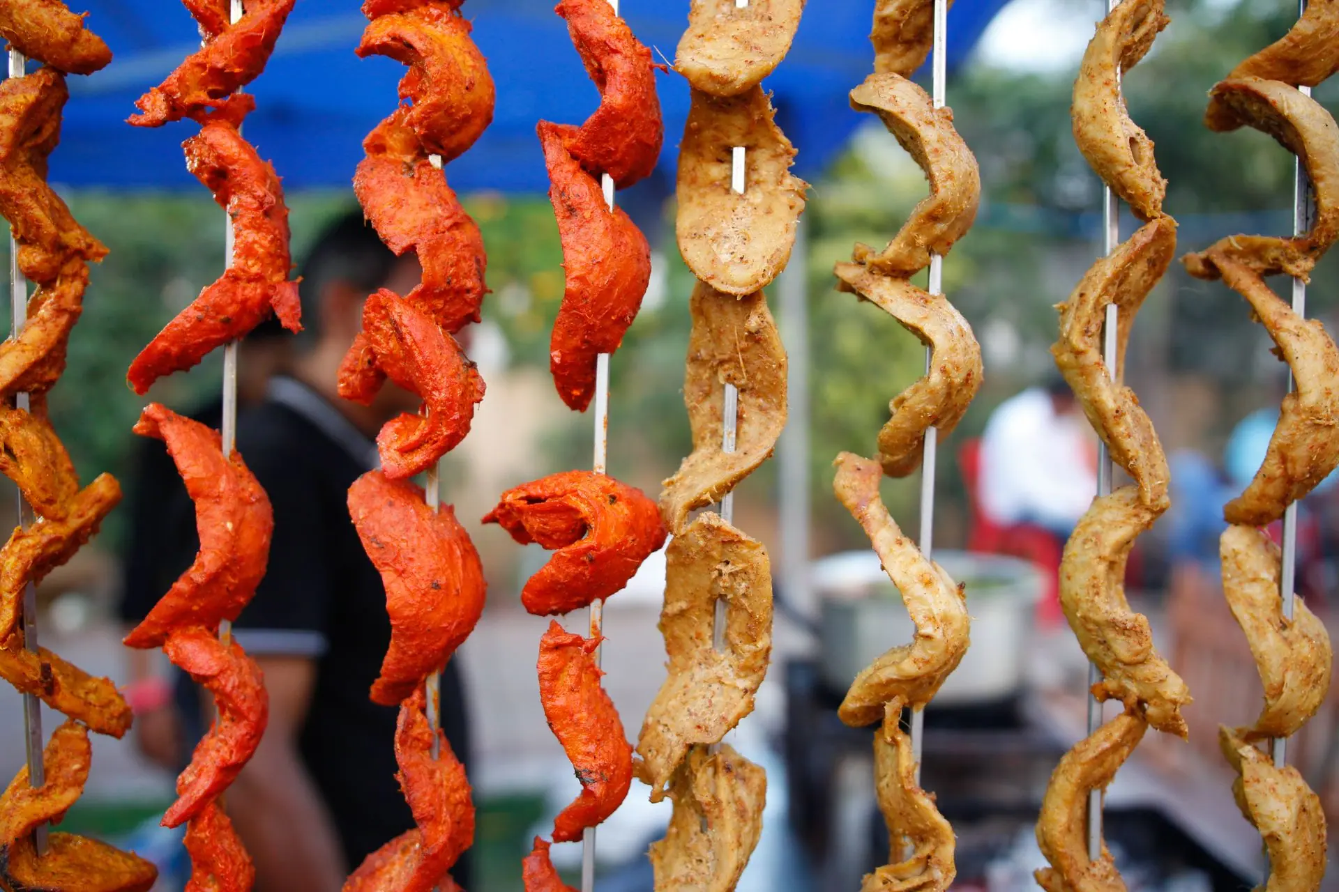 Vibrant skewers of Indian tandoori chicken on display at a street food market