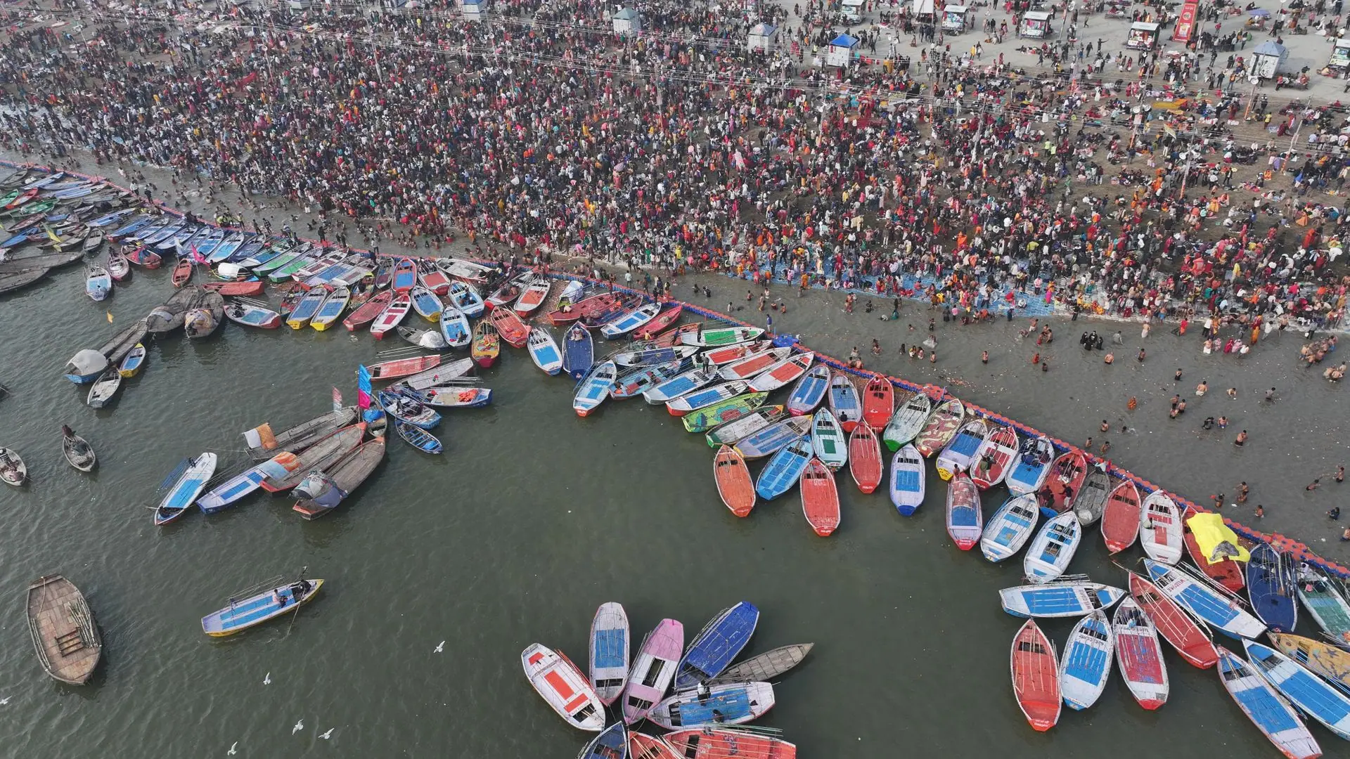 Aerial shot showcasing the bustling crowd and colorful boats at Kumbh Mela in Prayagraj