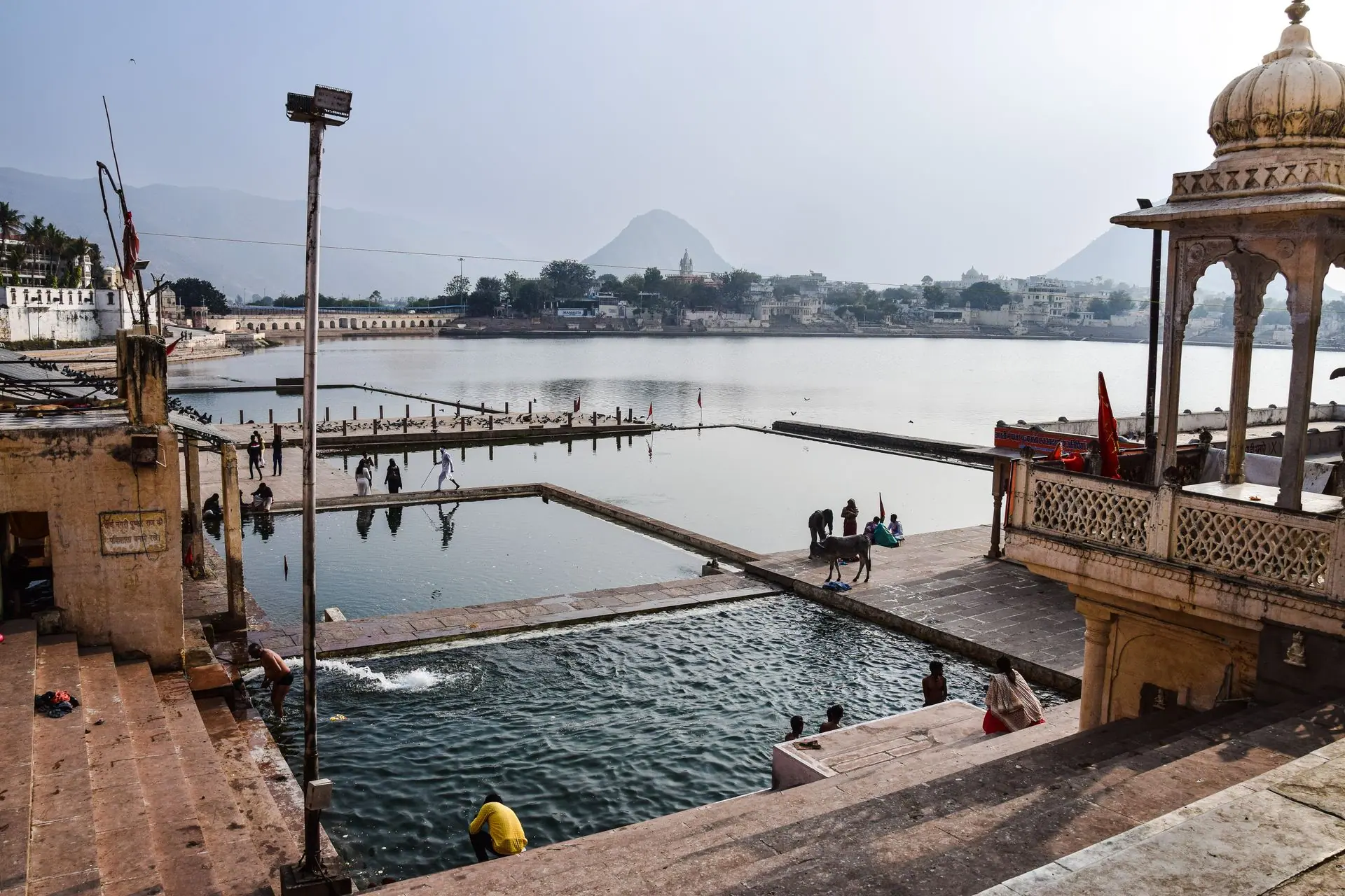 Tranquil view of Pushkar Lake with people and ghats in Rajasthan, India