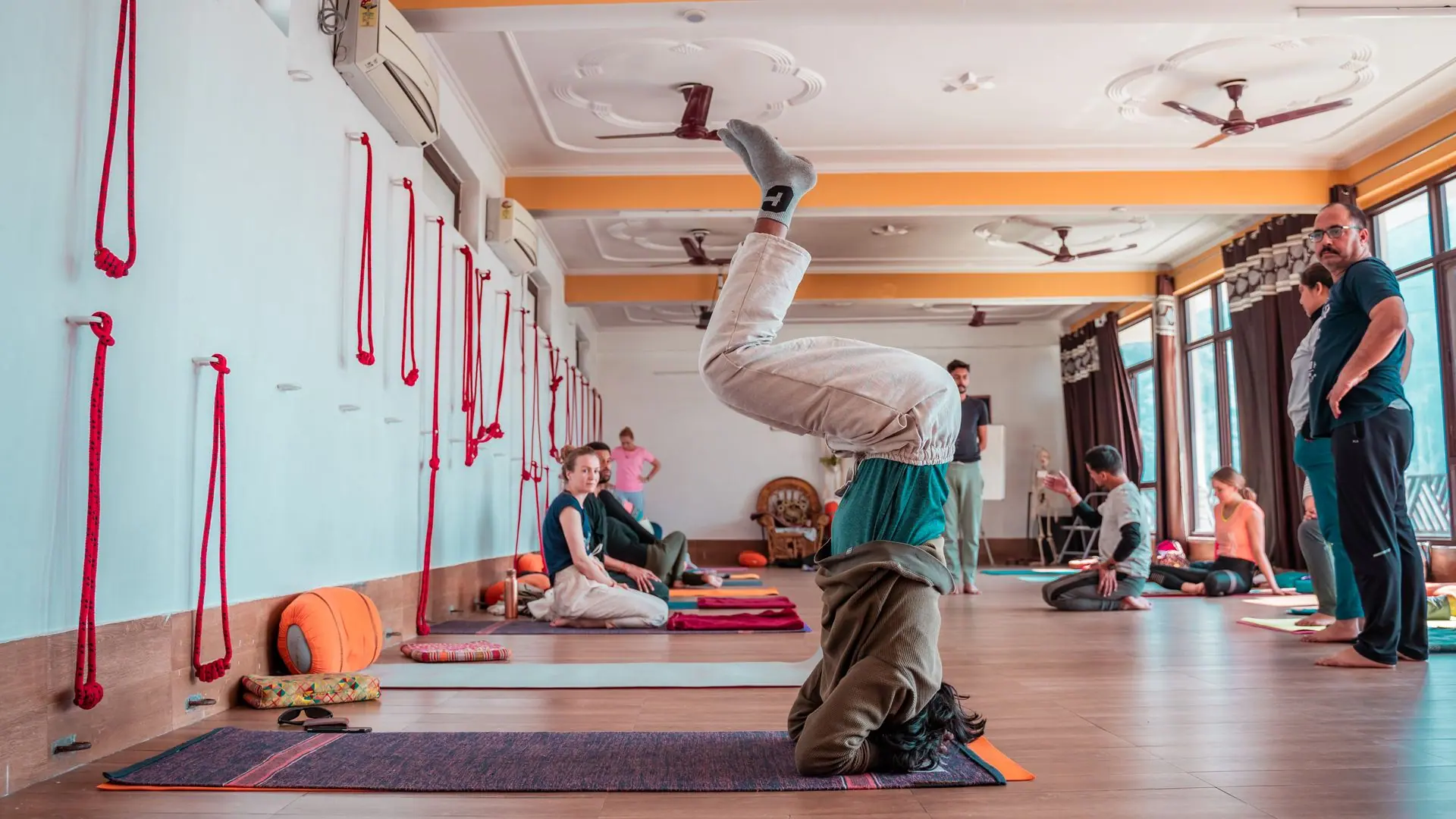 Participants practicing yoga in a Rishikesh studio, showcasing flexibility and wellbeing