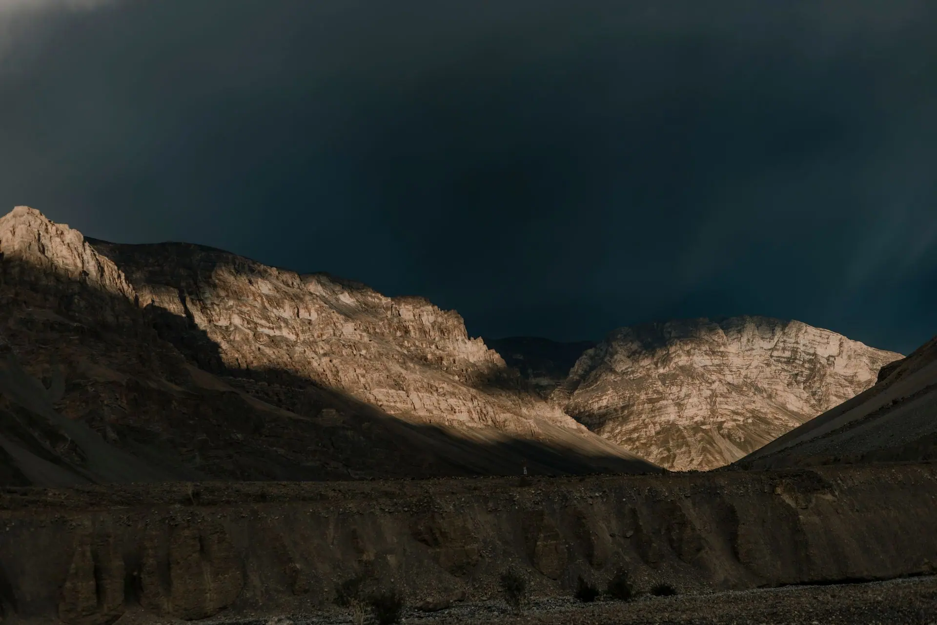 Dark clouds cast shadows over rugged mountains in Spiti Valley