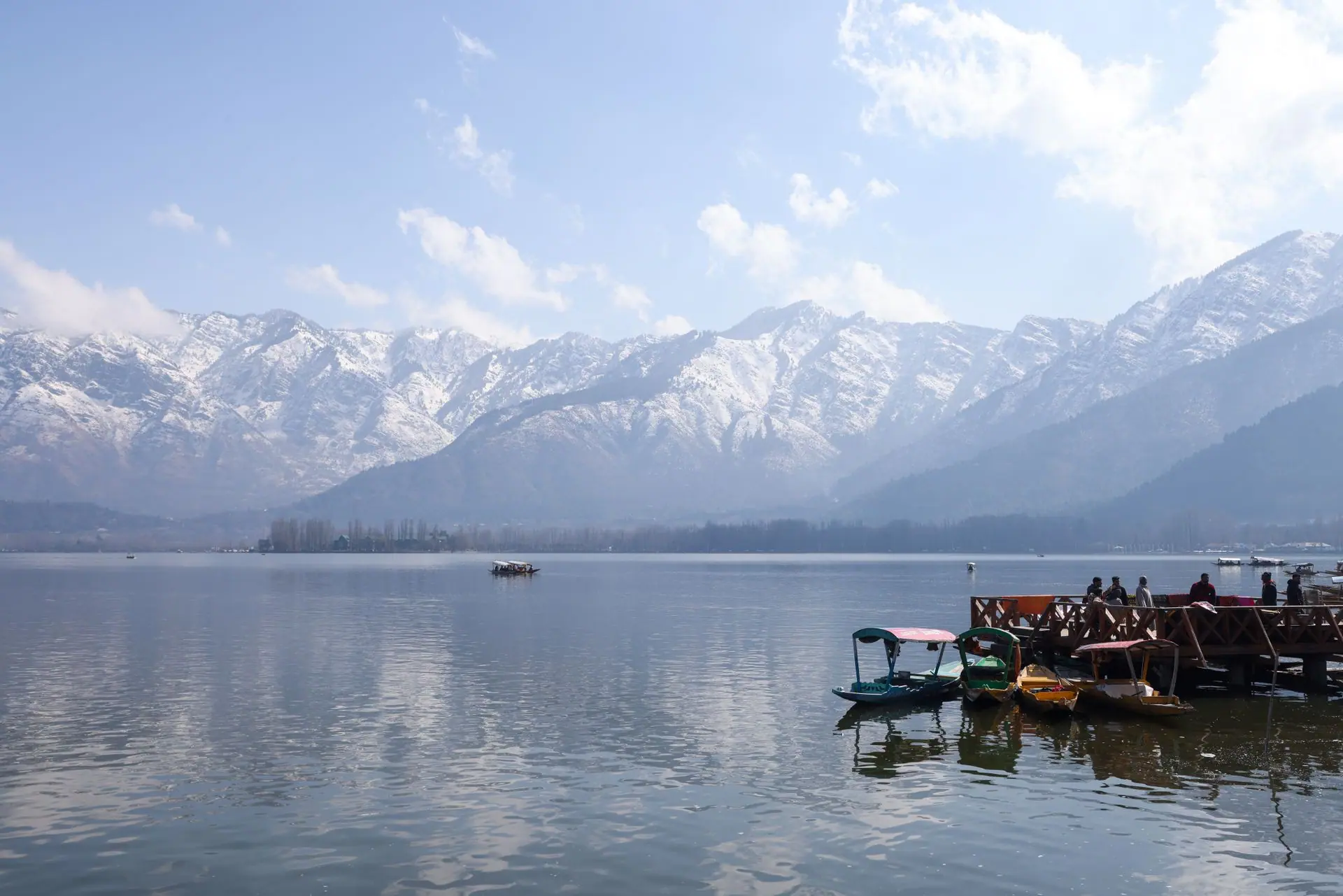 Boats on Dal Lake with snowcapped Himalayas in the background, serene Srinagar scene