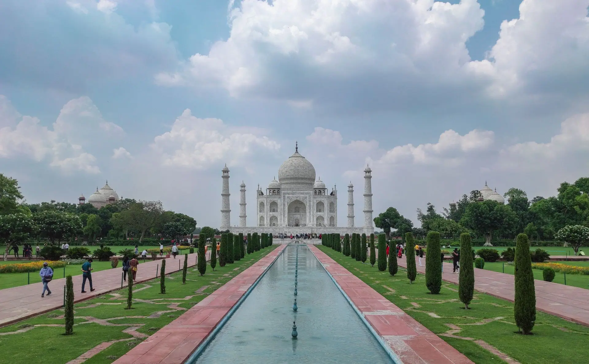 Captivating view of the Taj Mahal with gardens and tourists on a clear day