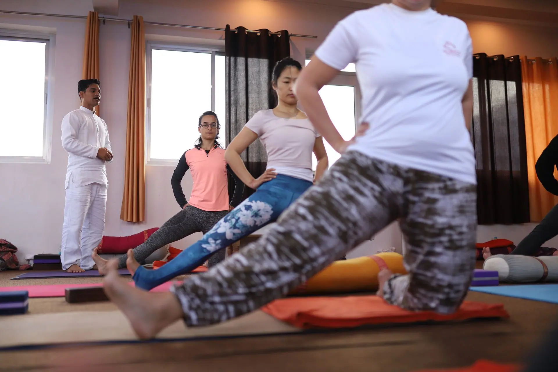 Group yoga session indoors with diverse students in Rishikesh yoga studio