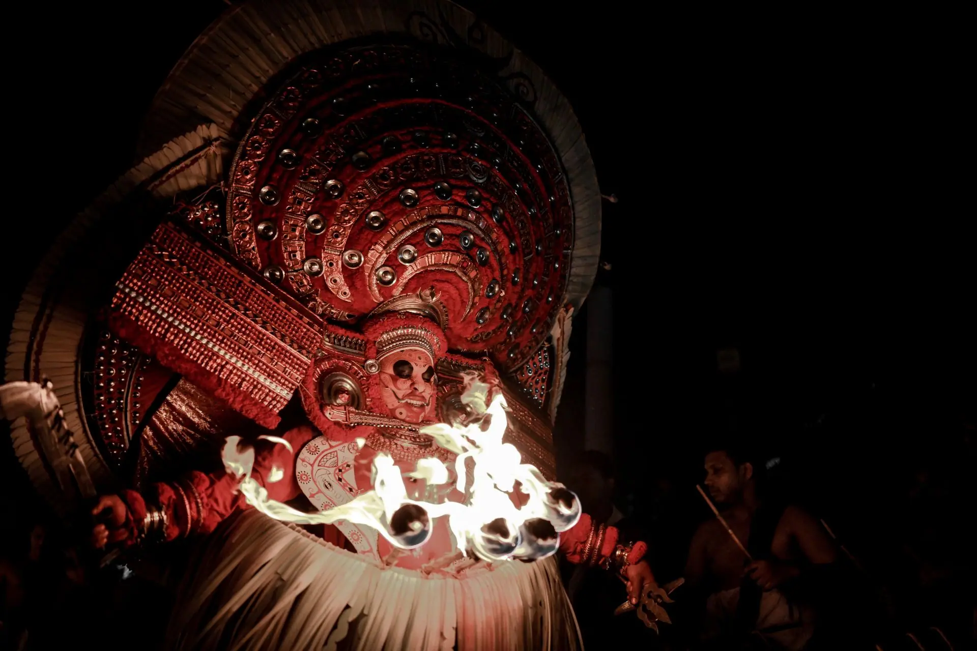 A captivating Theyyam performance featuring vibrant costumes and fire rituals under the night sky